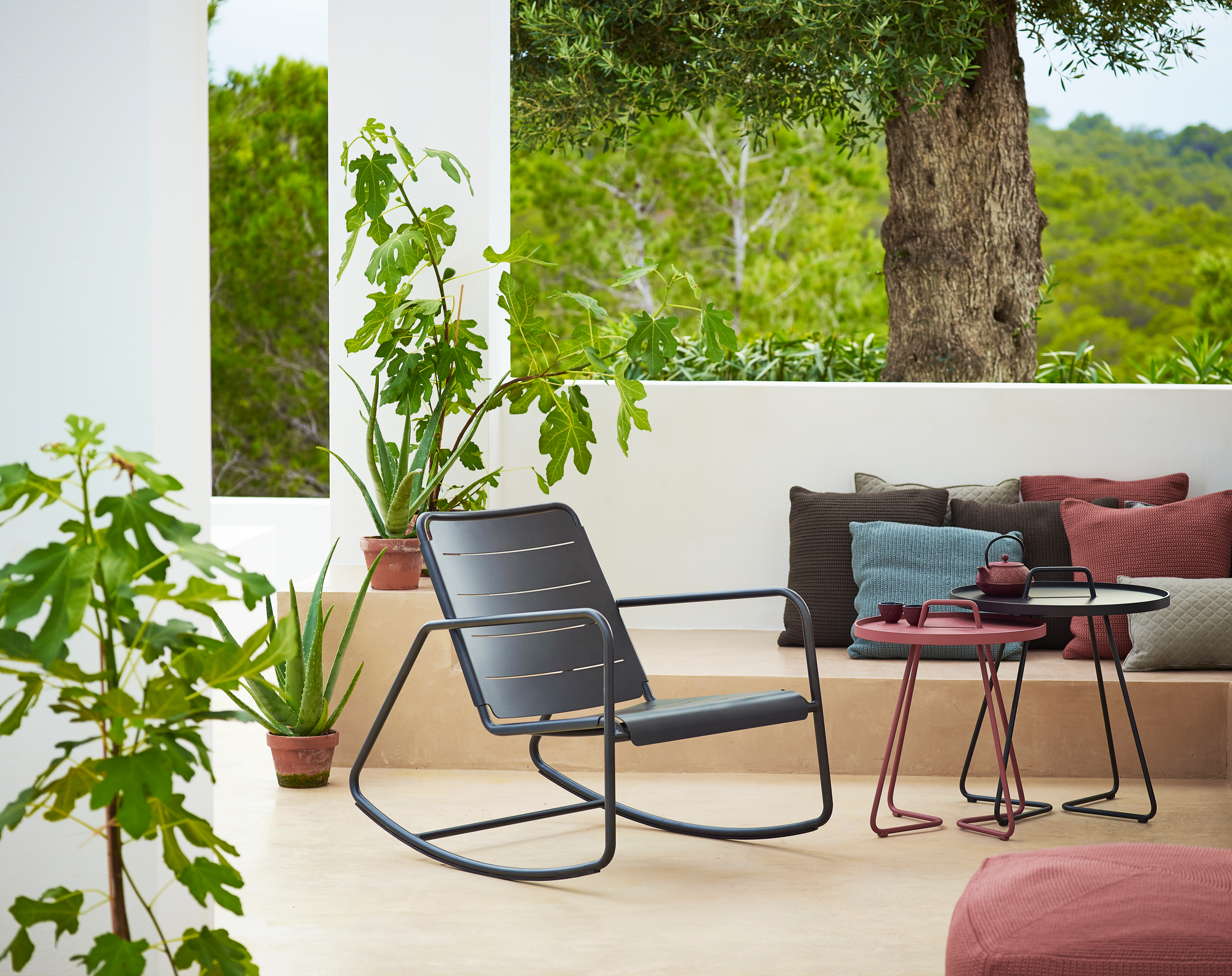 Cane-Line Copenhagen Schaukelstuhl im Außenbereich, modernes Design, graues Metallgestell, entspannende Gartenmöbel.