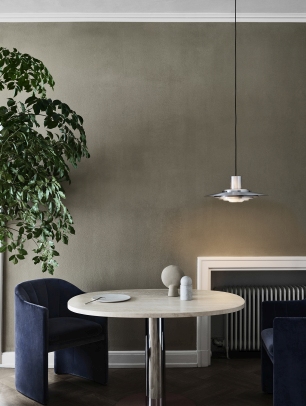 Esszimmer mit Loafer Sessel SC24 von AndTradition in Blau, rundem Tisch und moderner Hängelampe.