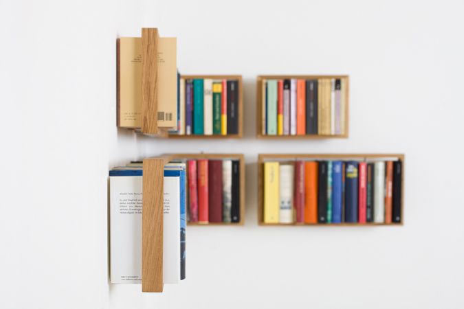 Regal b Eiche, kleine Wandregale aus Eichenholz mit Büchern an einer weißen Wand.