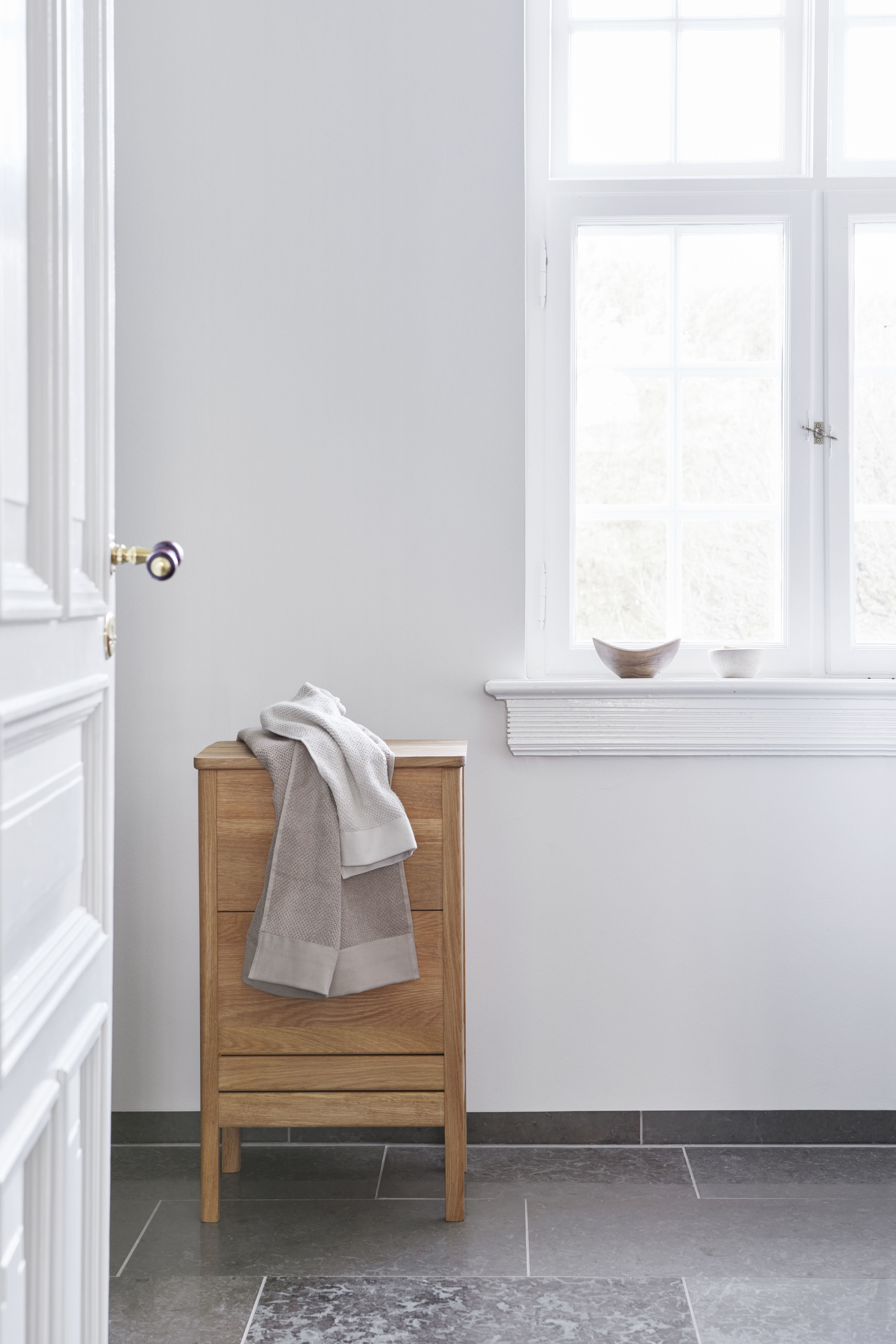 A Line Waschtisch Eiche weiß geölt von Form & Refine mit Handtuch im Badezimmer.