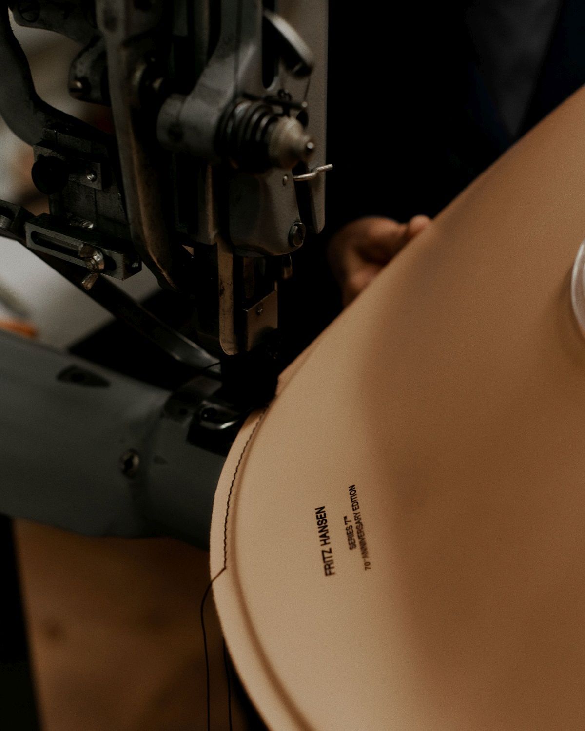 Detailaufnahme einer Nähmaschine, die Leder für den Fritz Hansen Siebener Stuhl (Serie 7) bearbeitet.