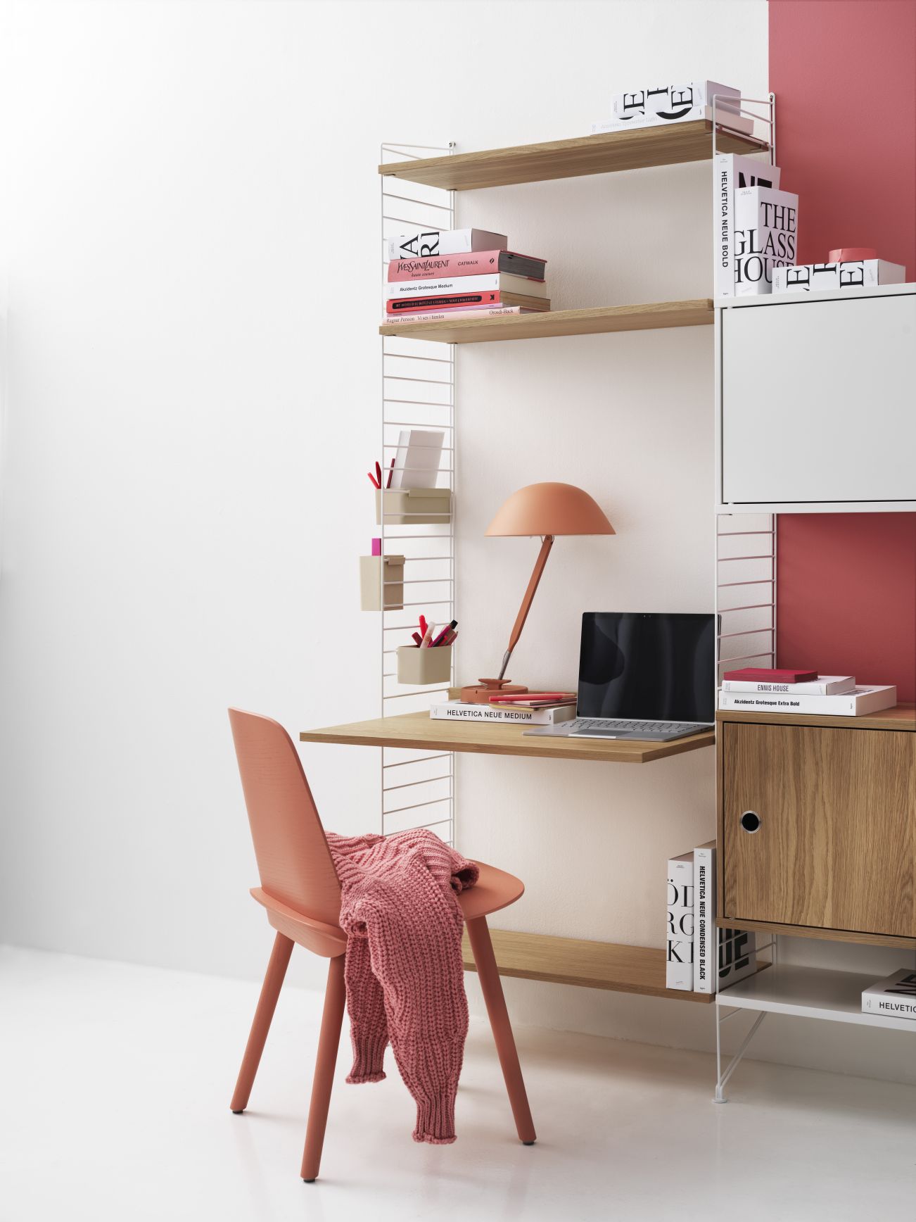 Beige String Regalsystem an der Wand mit Schreibtisch, Lampe, Laptop und Stuhl.