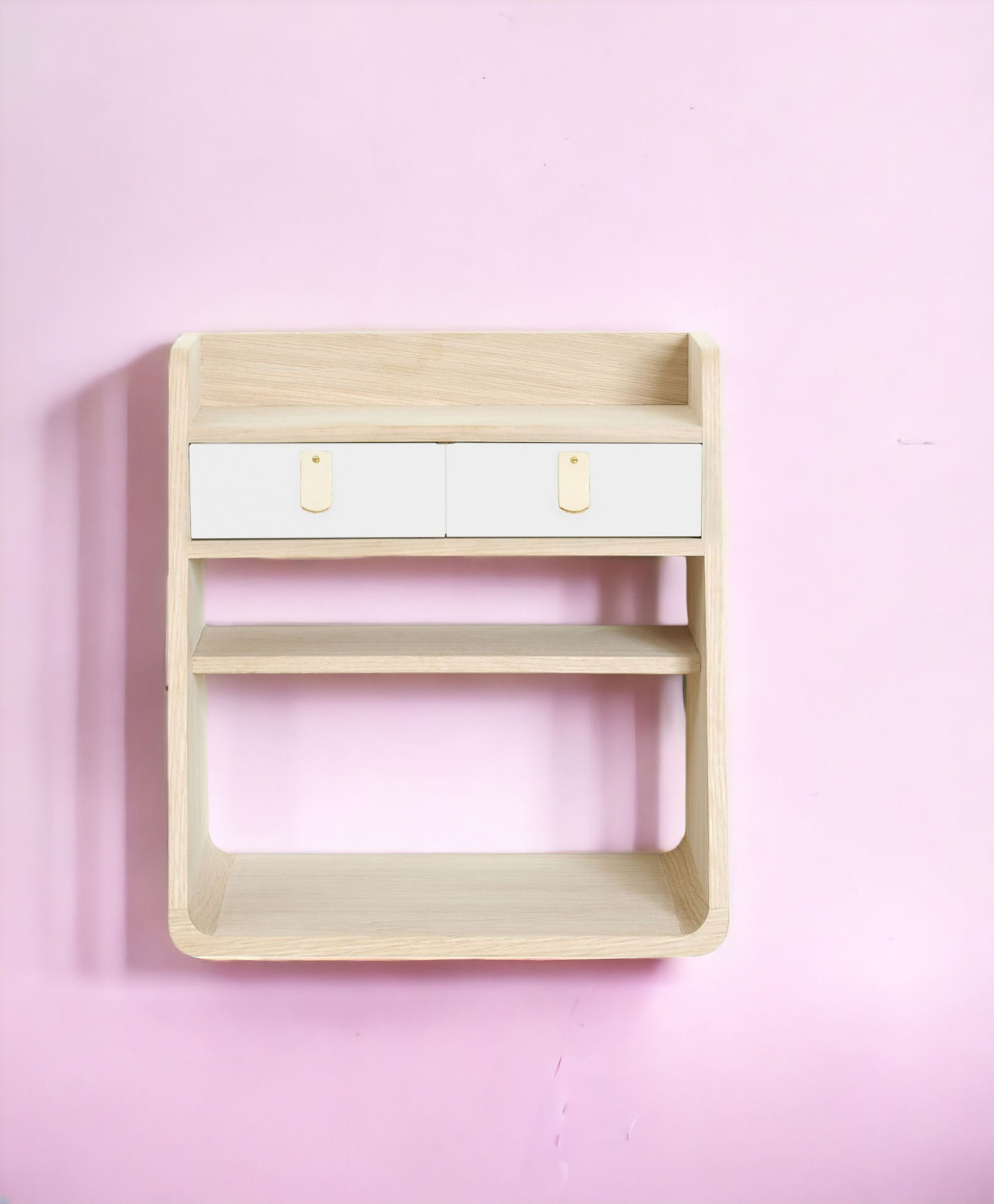 Helles Holz Wandregal mit zwei weißen Schubladen und Ledergriffen vor rosa Wand.