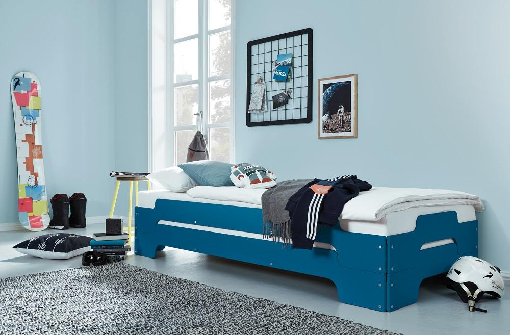 Blaue Stapelliege Komfort von Müller Möbelwerkstätten im Jugendzimmer mit Snowboard, Helm und Deko.