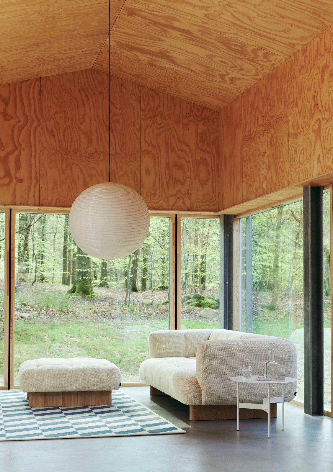 Wohnzimmer mit Sofa, Beistelltisch und blau-weißem Shift Kelim Rug Teppich von Hay auf dem Boden.