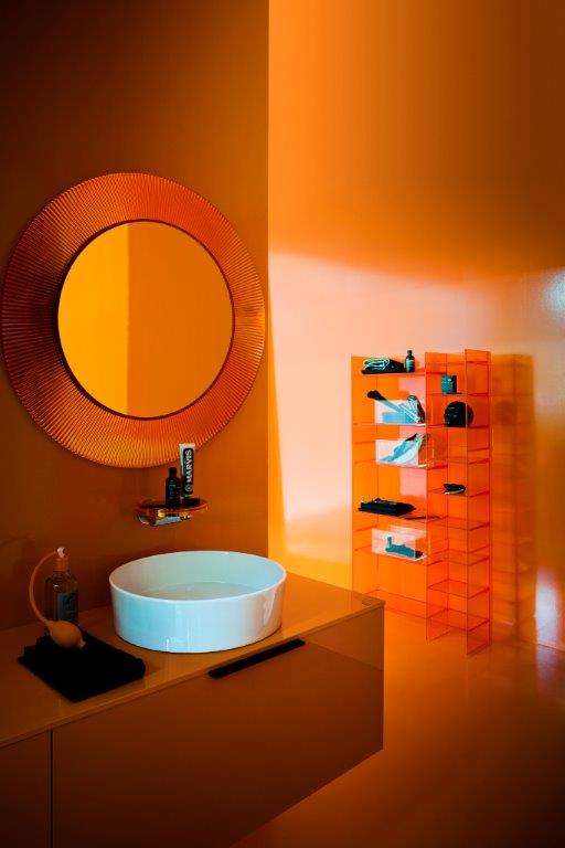 Oranger All Saints Spiegel von Kartell im Badezimmer mit Waschbecken und Regal.