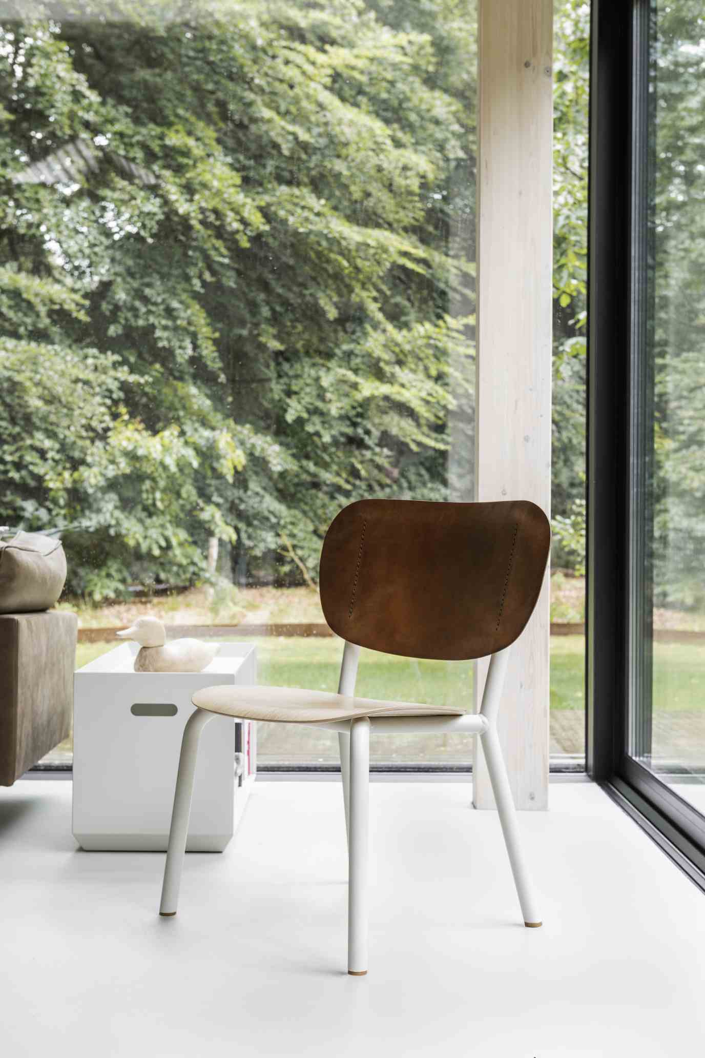 Emil Rosi Chair Stuhl mit brauner Rückenlehne und weißen Beinen vor Fenster. Designstuhl.