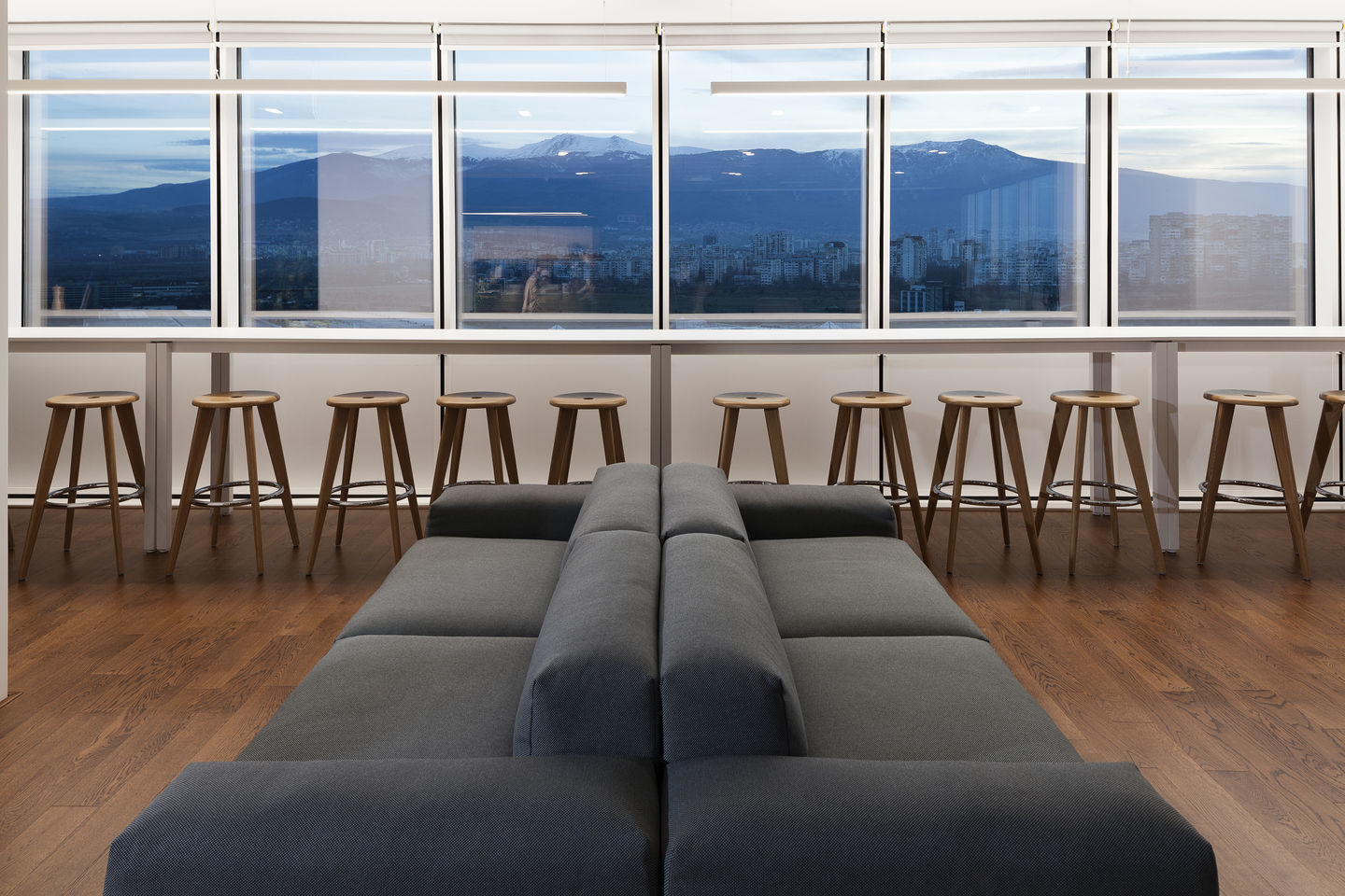 Tabouret Haut Barhocker von Vitra in modernem Büro mit Holzböden und Stadtblick.