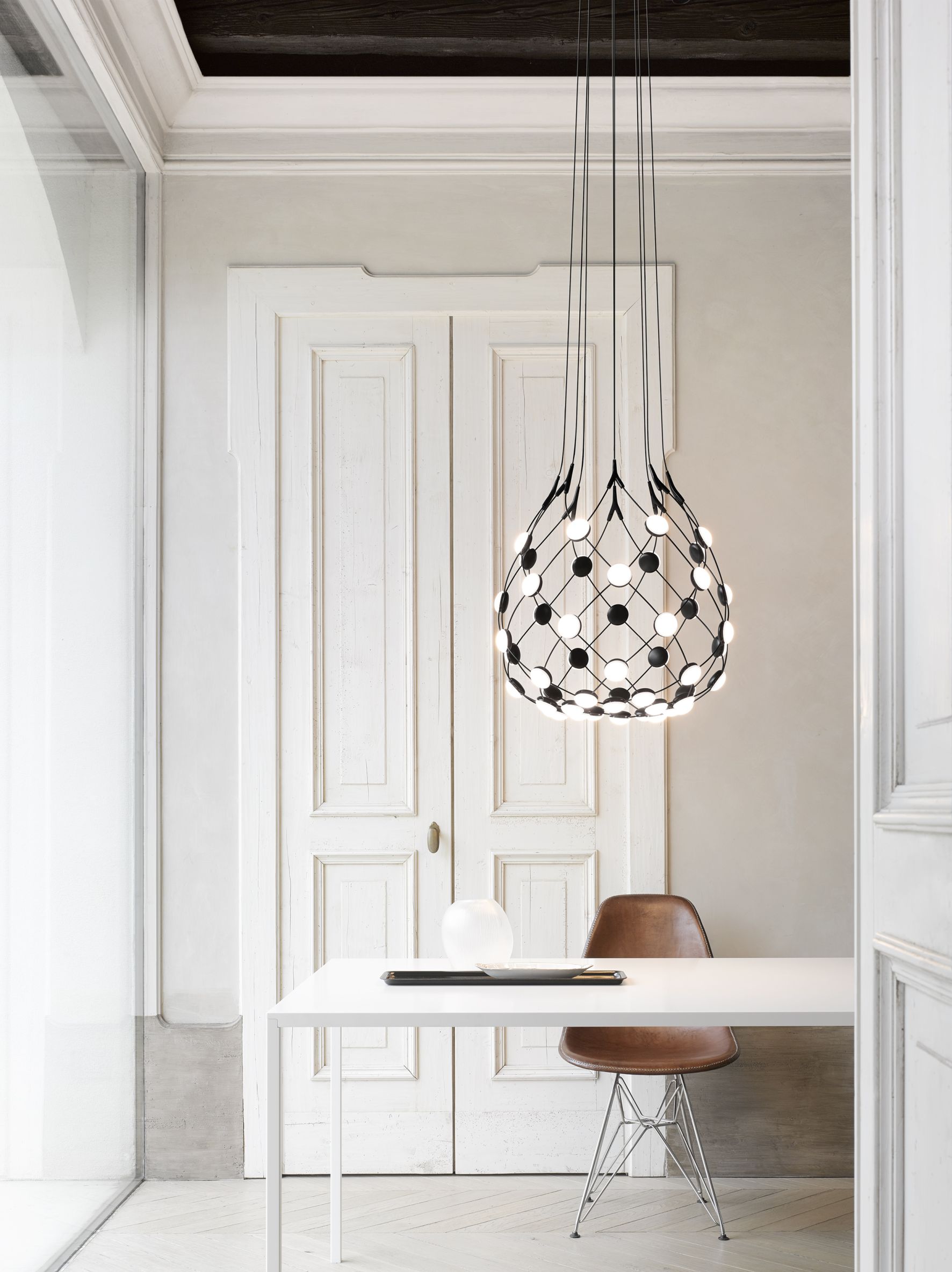 D86 Mesh Deckenleuchte von Luceplan über Esstisch. Moderne Design Lampe mit schwarzem Netz.