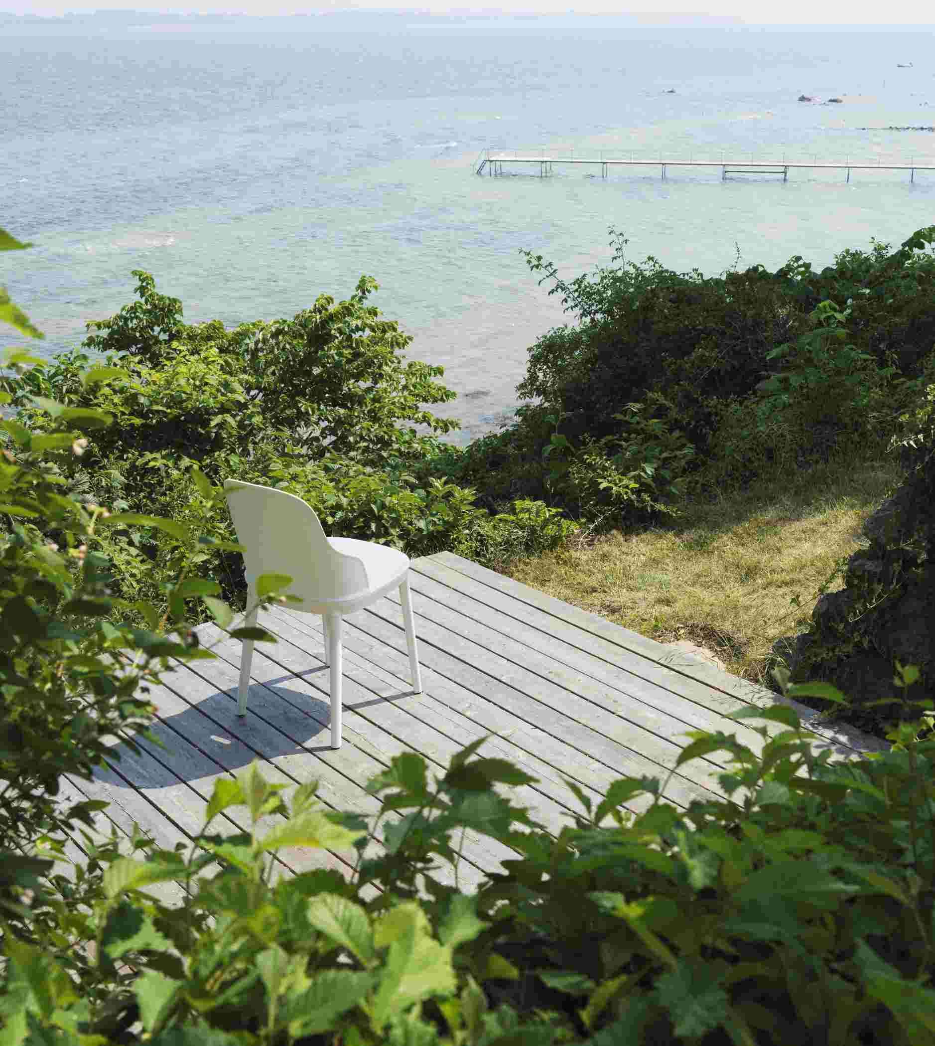 Weißer Allez Chair Stuhl von Normann Copenhagen auf Holzterrasse mit Meerblick, minimalistisches Design und skandinavische Möbel.