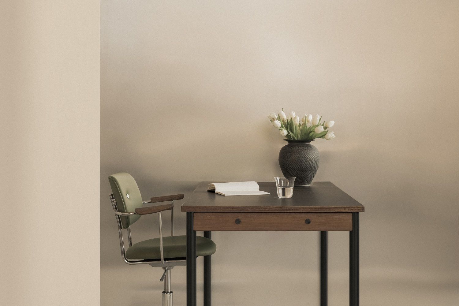 Co Task Chair von Audo Copenhagen in Grün am Schreibtisch mit Tulpen in Vase.