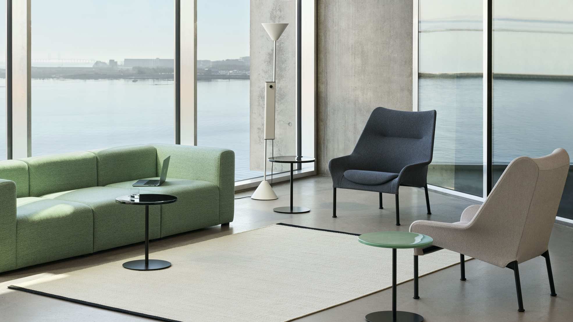 Heller Raum mit grünem Sofa, Stehlampe und zwei 02 Lounge Chair Sesseln von Hay.