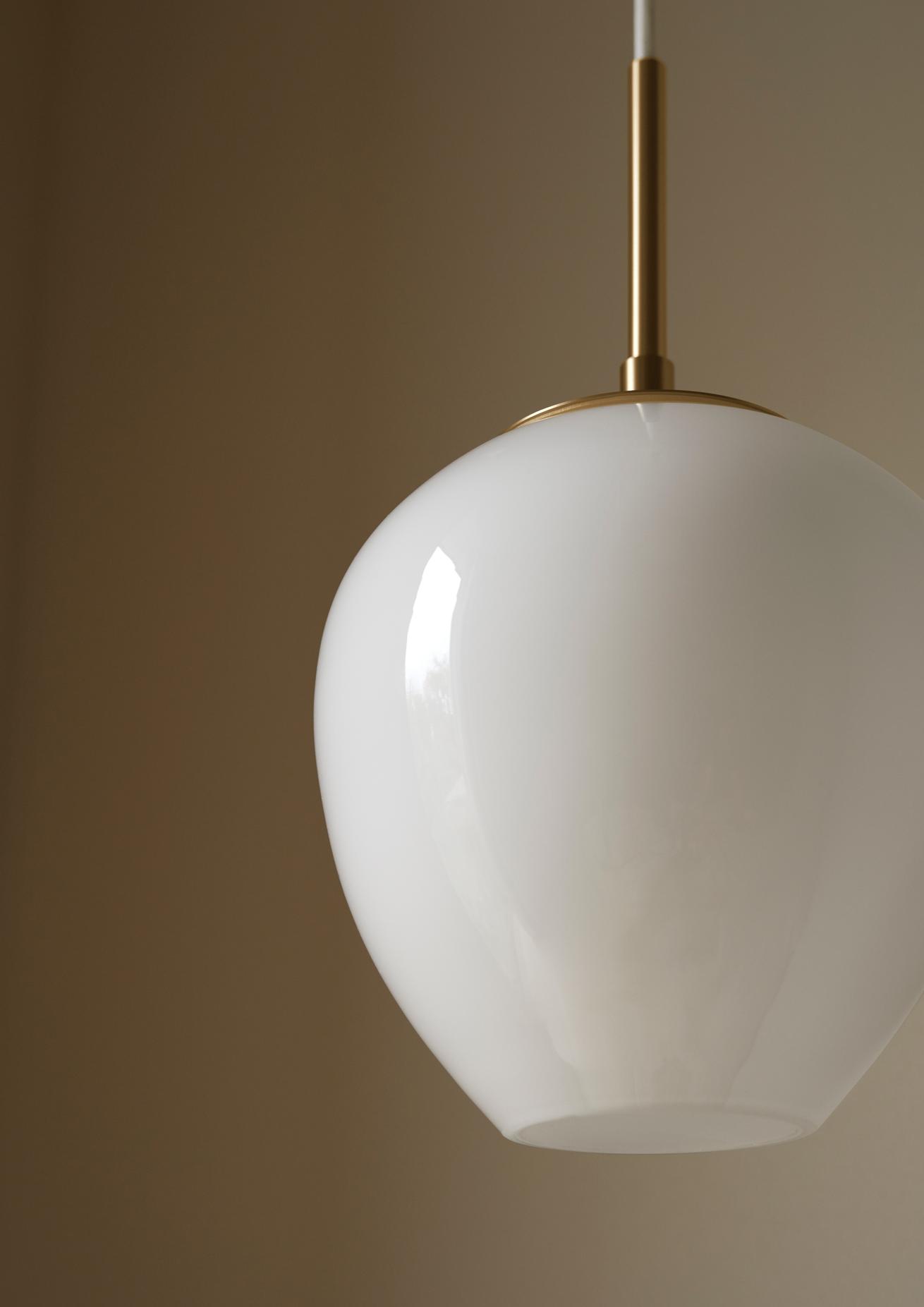 Nahaufnahme der Tulip Pendelleuchte von Carl Hansen & Søn, weißes Glas mit Messingdetails.