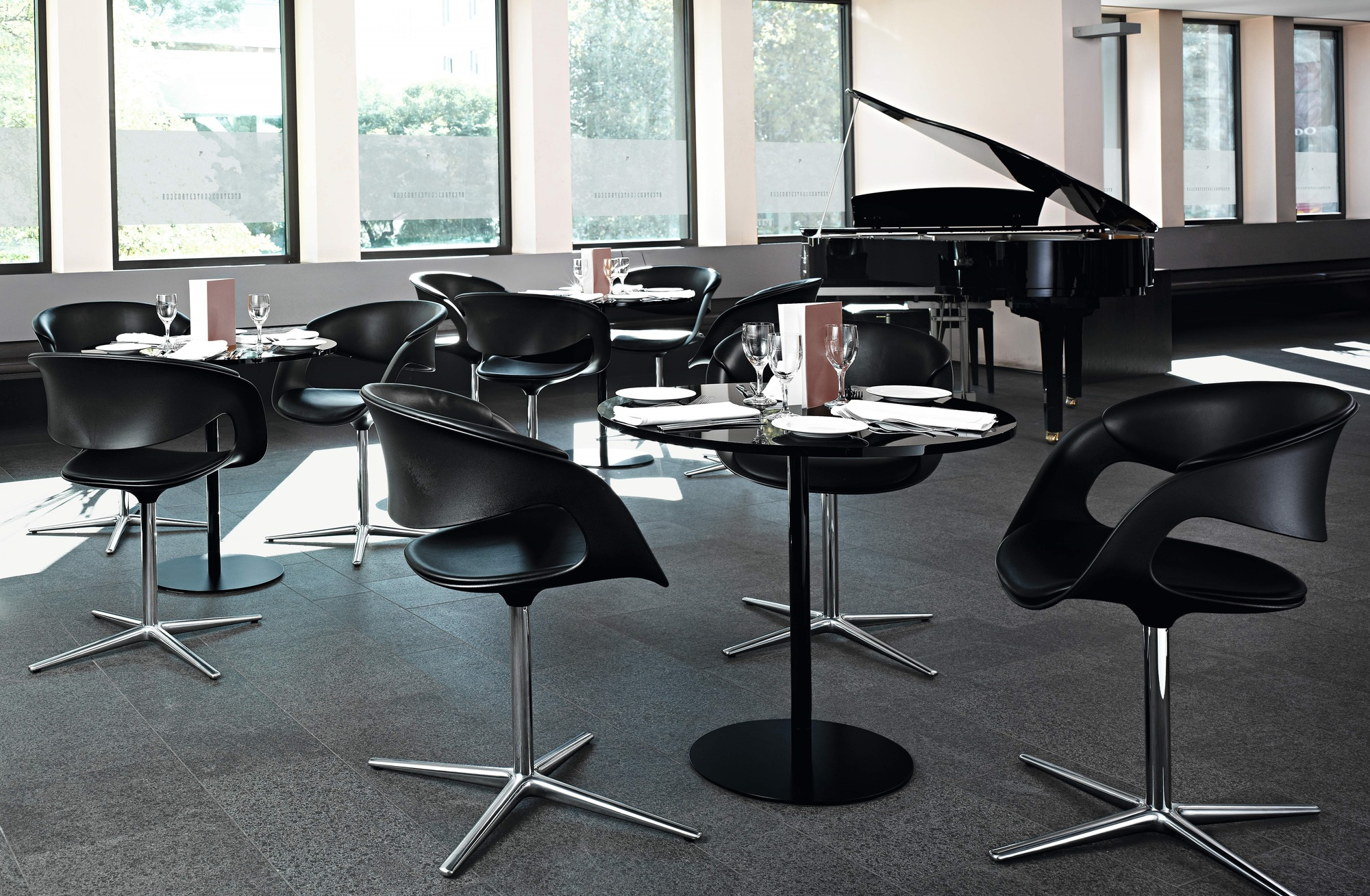 Schwarzer Lox Sessel von Walter Knoll in modernem Ambiente mit Tischen und Klavier.
