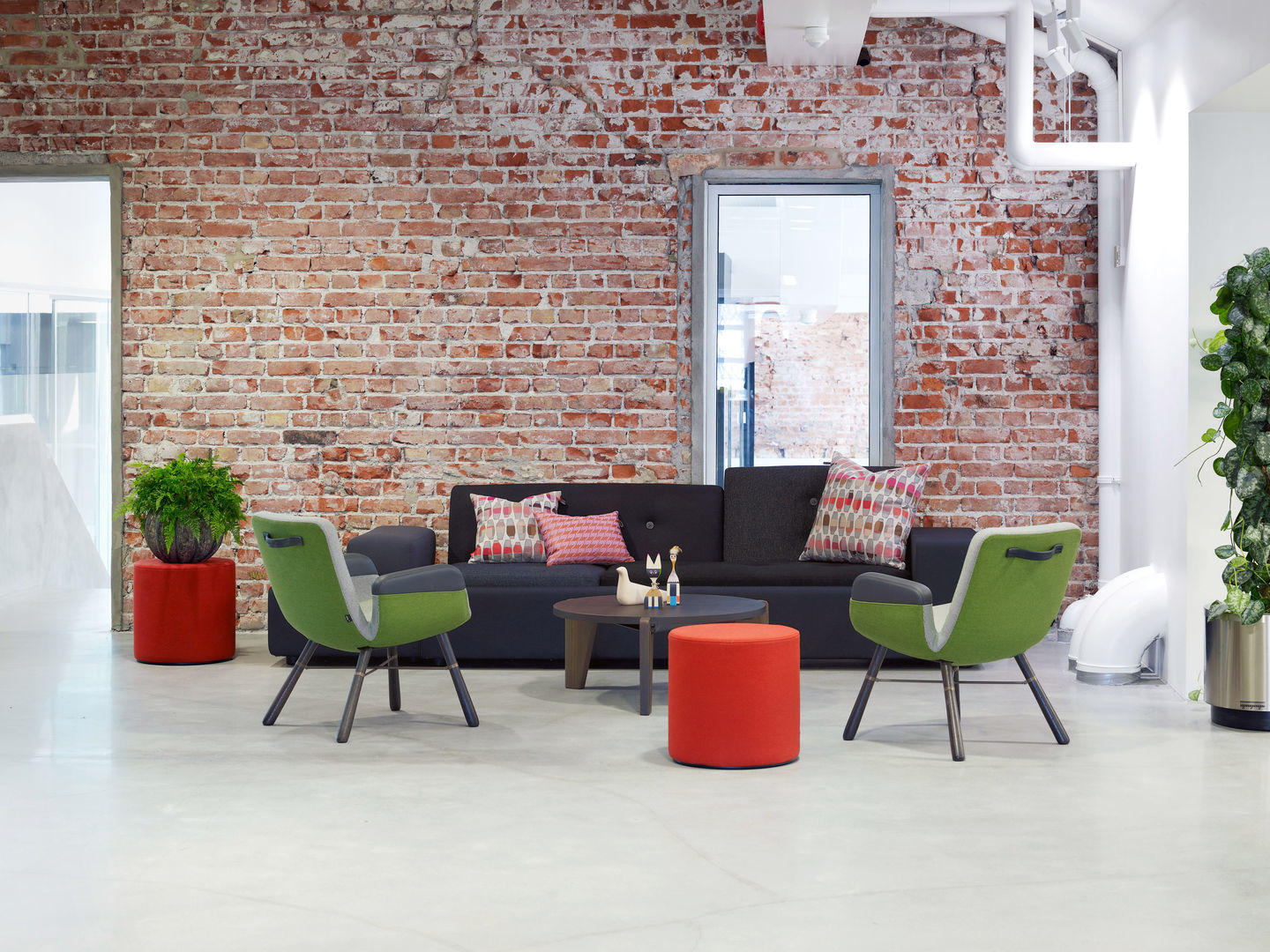 East River Chair von Vitra in Grün und Grau vor einer Backsteinwand im Wohnzimmer.