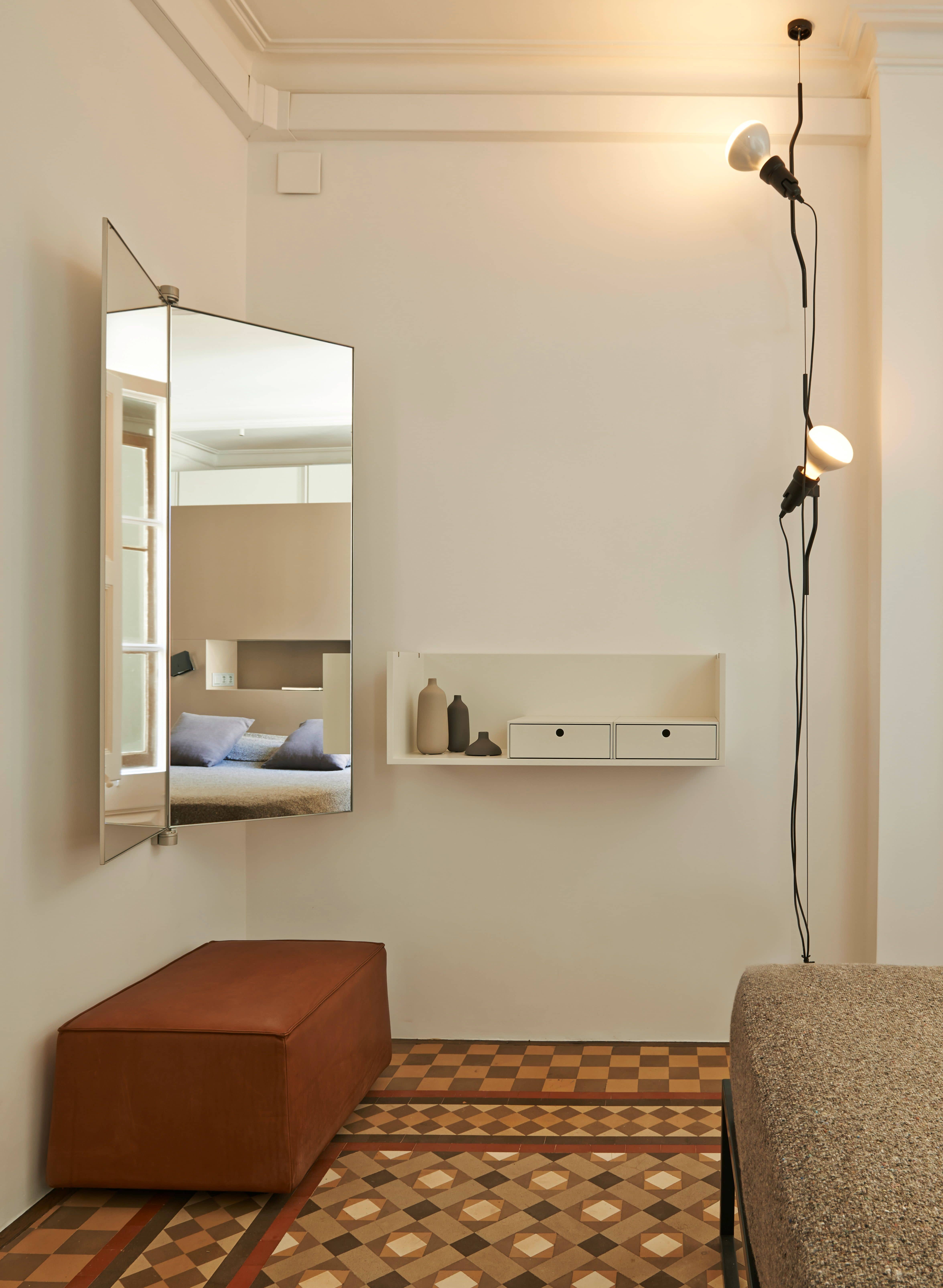 Modernes Schlafzimmer Interieur mit Spiegel, Wandregal, braunem Hocker und dekorativer Lampe für stilvolles Wohnen.