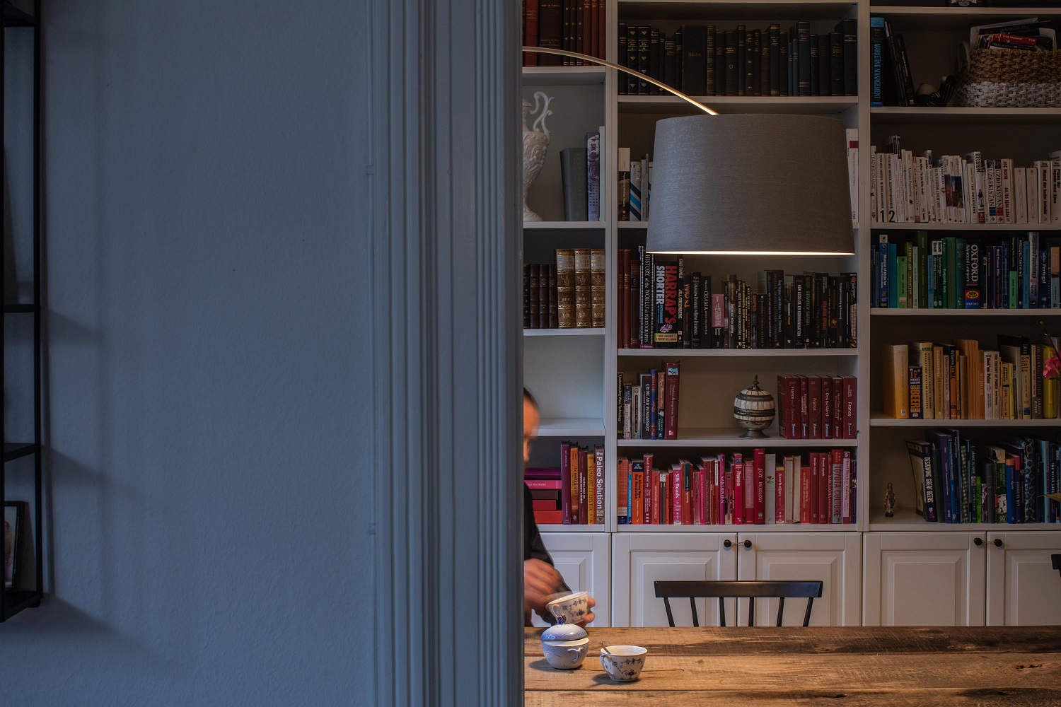Twiggy Stehleuchte von Foscarini über Esstisch vor Bücherregal, modernes Lampendesign für Wohnzimmer und Essbereich.