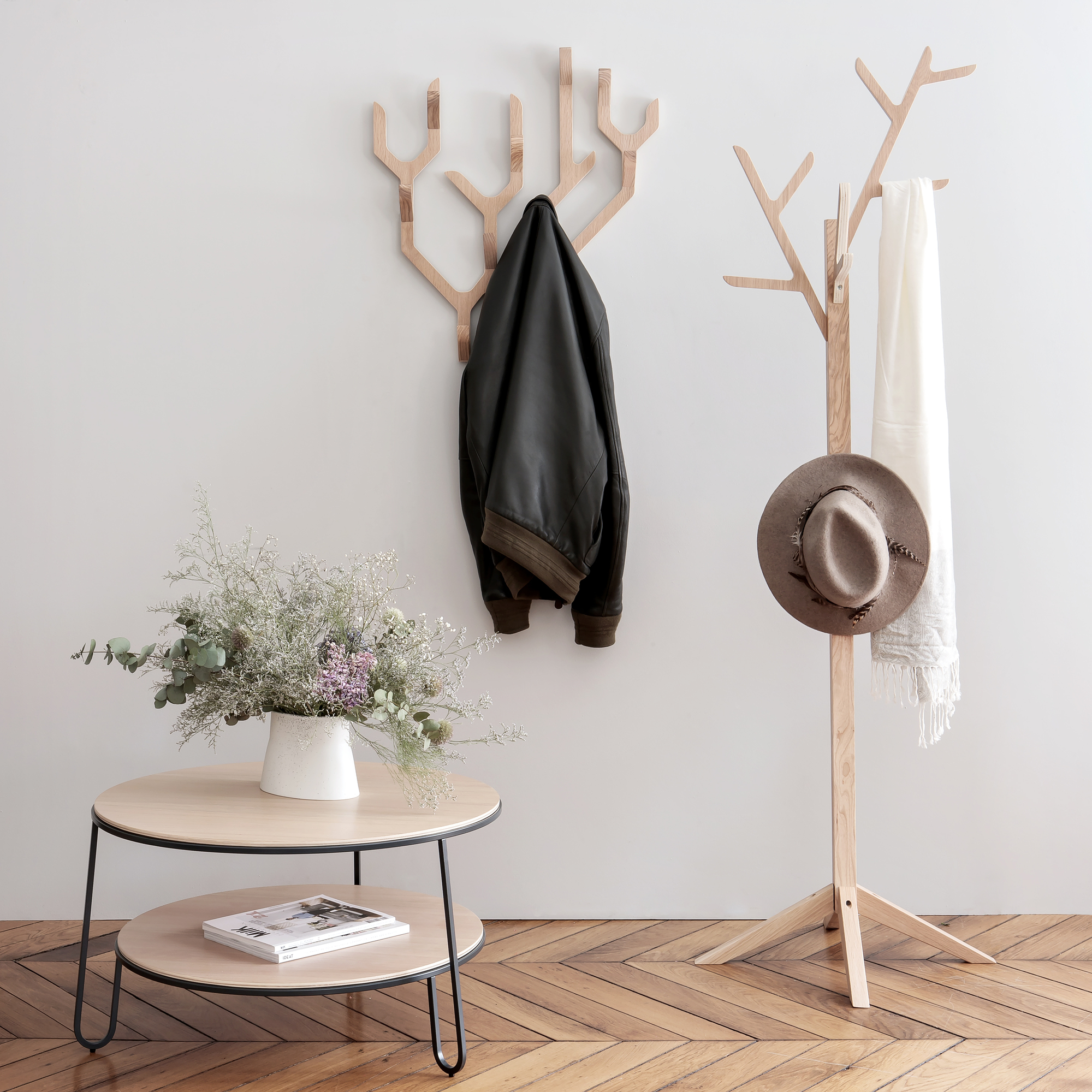 Ambroise Wandgarderobe von Hartô aus Holz mit Jacke, Hut und Schal an Wand und Boden.