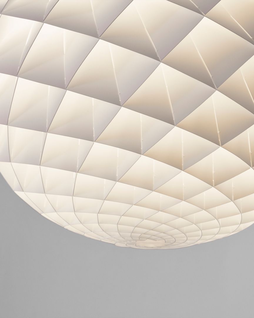 Detailaufnahme der Louis Poulsen Patera Pendelleuchte mit geometrischem Design und warmem Lichtschein, moderne Deckenleuchte.