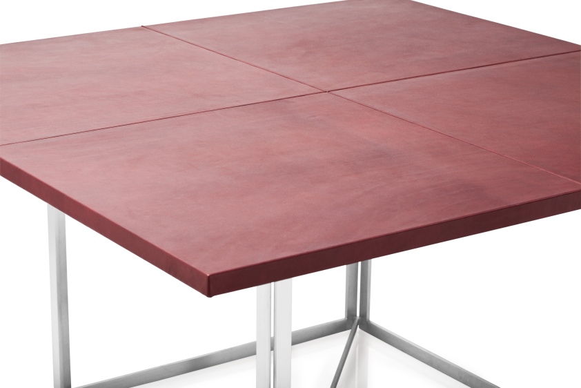 Detailaufnahme des PK40 Esstischs von Fritz Hansen mit roter Tischplatte und Stahlgestell.