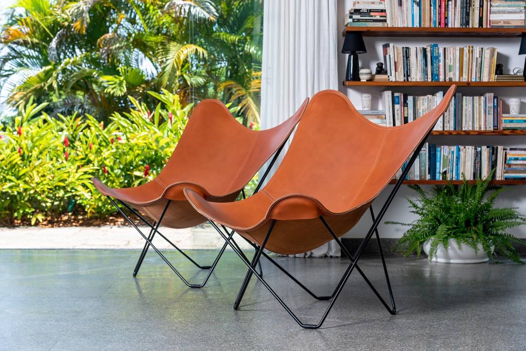 Zwei braune Pampa Mariposa Butterfly Sessel aus Leder mit schwarzem Gestell im Wohnzimmer.