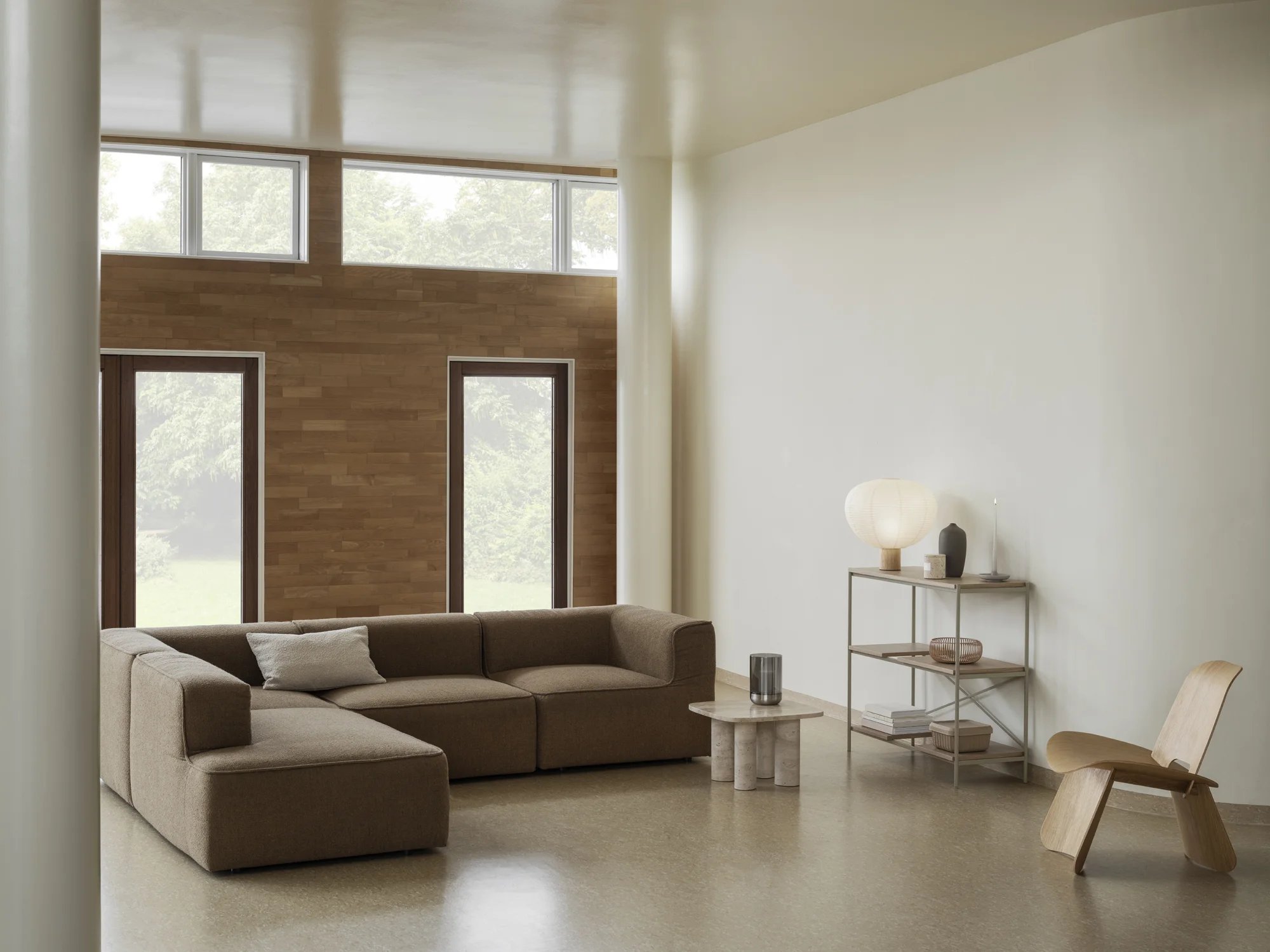 Helle Wohnzimmer-Szene mit Blomus Kami Reispapier Tischleuchte auf einem Regal, neben einem beigen Sofa.