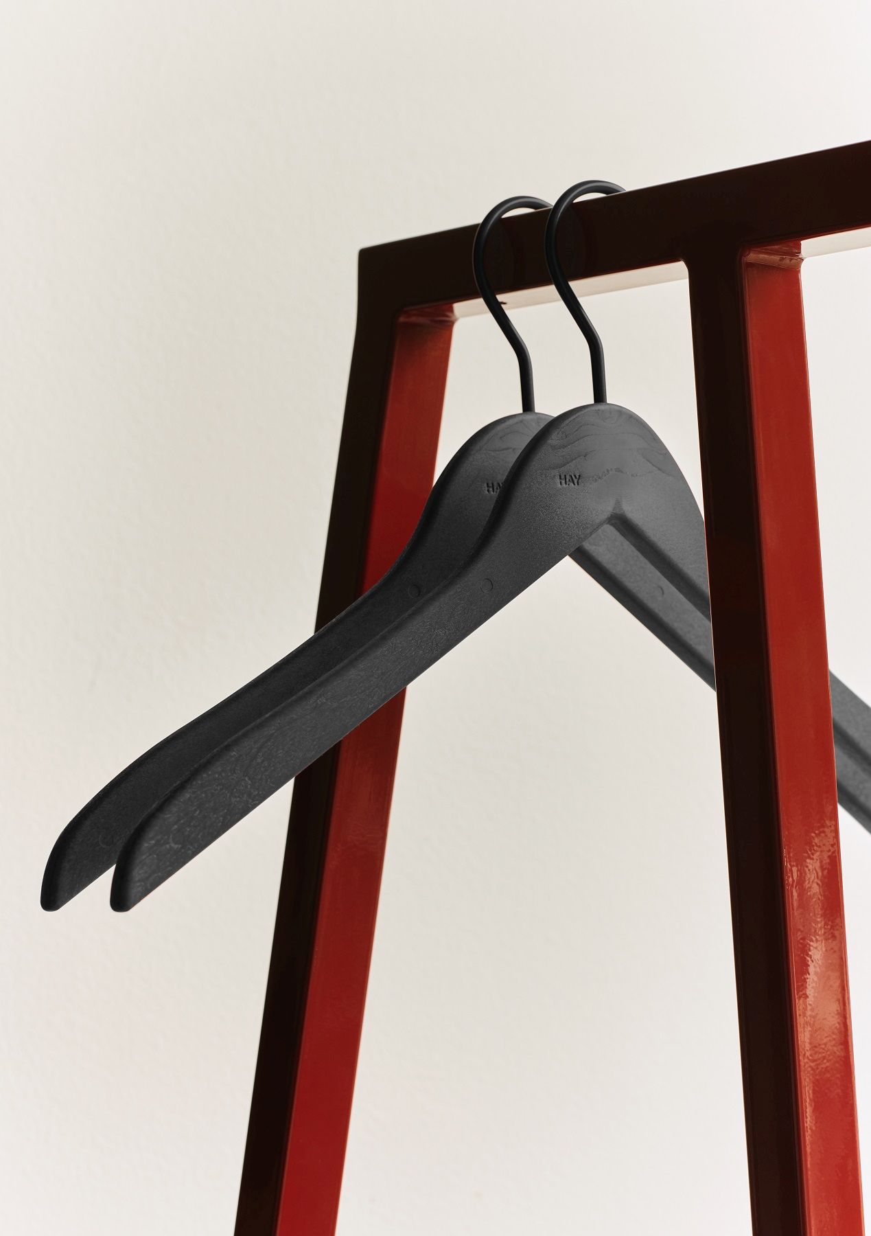 Nahaufnahme der Hay Loop Stand Hall Garderobe mit zwei schwarzen Kleiderbügeln.