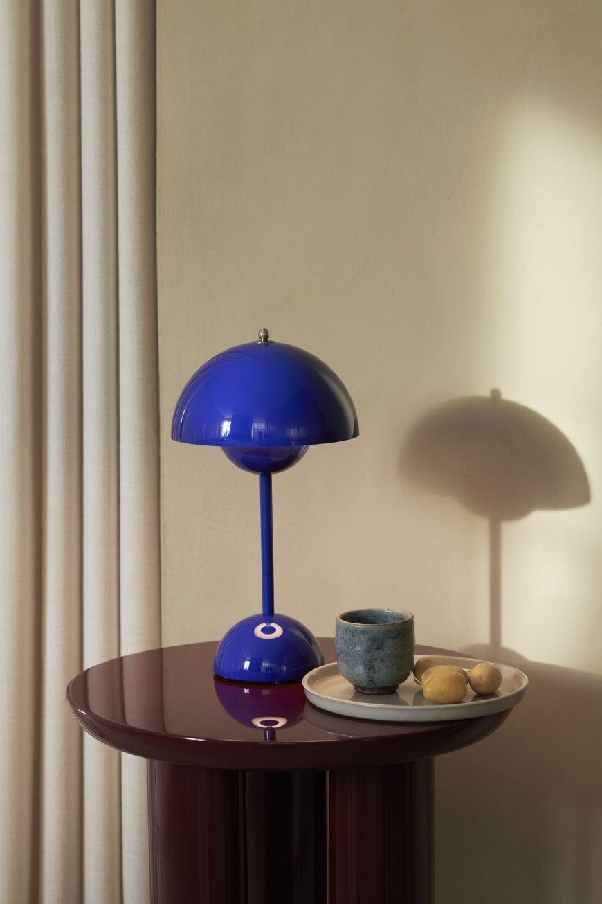 Flowerpot VP9 Akkuleuchte in Kobaltblau von AndTradition auf einem Tisch. Designleuchte, Tischlampe.