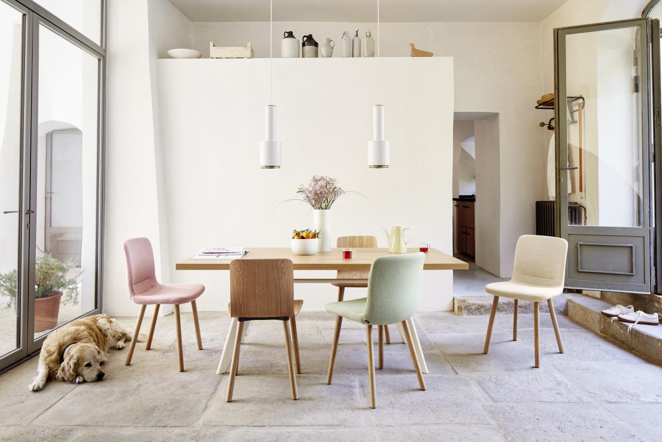Esszimmer mit Holztisch und vier Hal Stühlen von Vitra in verschiedenen Farben.