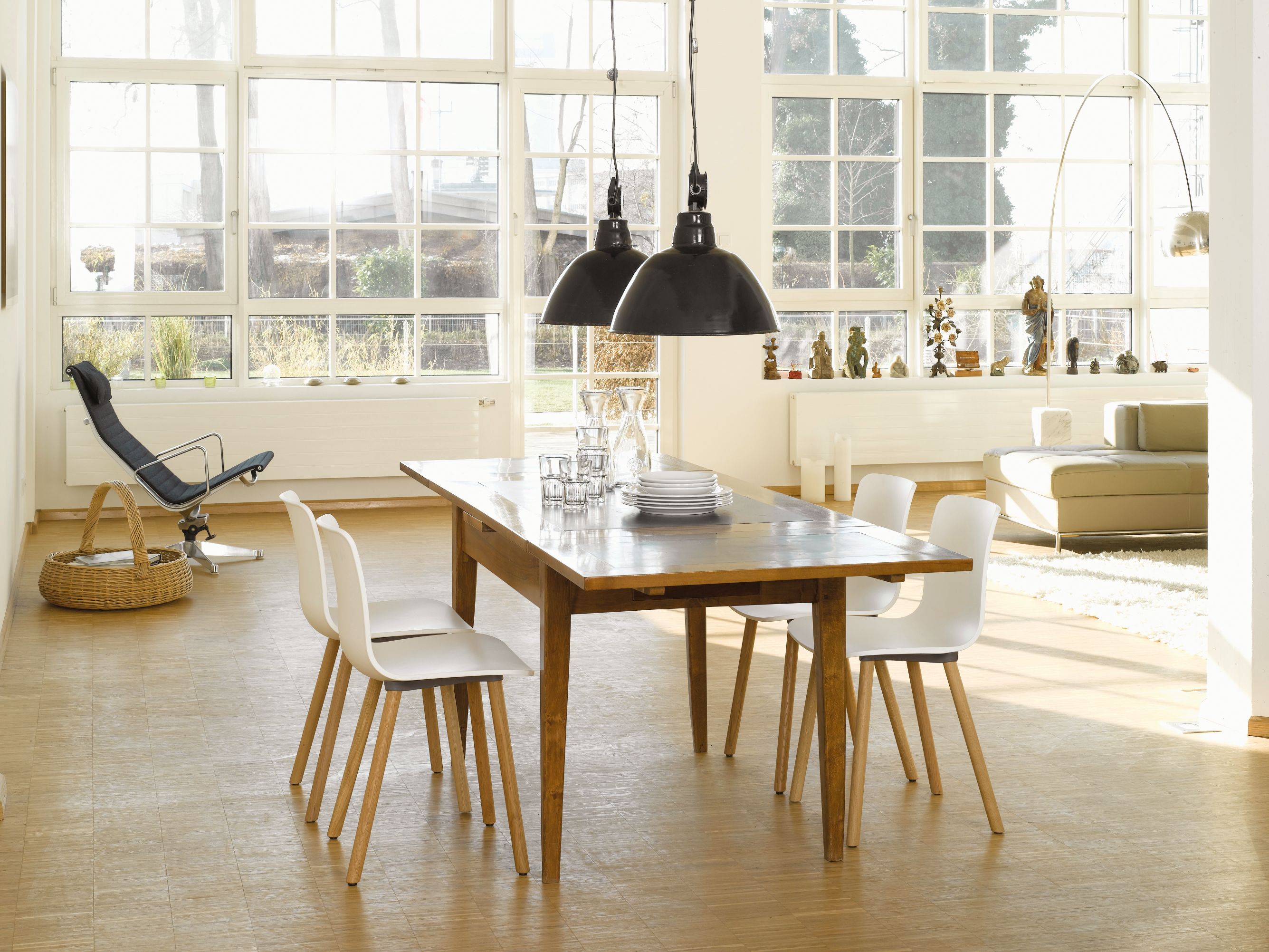 Heller Raum mit Holztisch und vier weißen Hal Stühlen von Vitra mit Holzbeinen.
