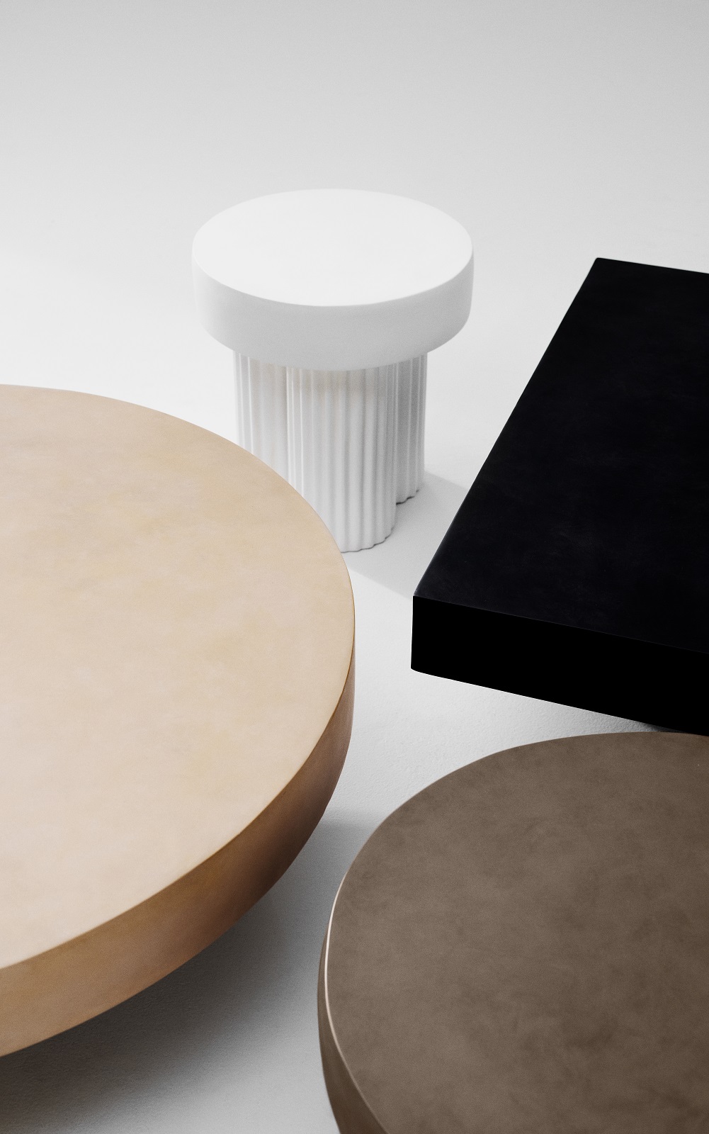 Norr11 Gear Square Couchtisch: Nahaufnahme von runden und eckigen Couchtischen in verschiedenen Farben.