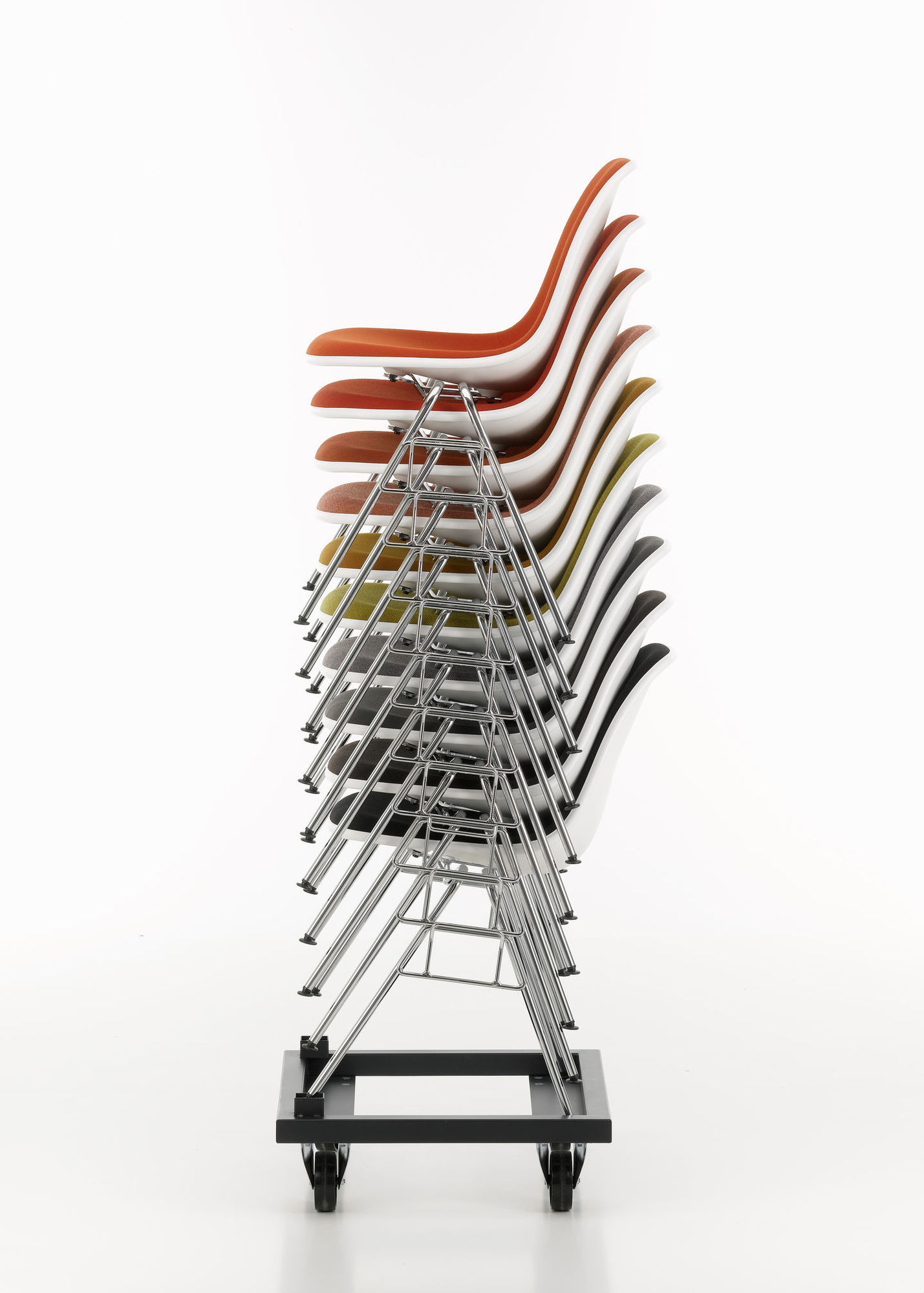 Gestapelte Eames Plastic Side Chairs von Vitra, vollgepolstert, in verschiedenen Farben auf einem Transportwagen.