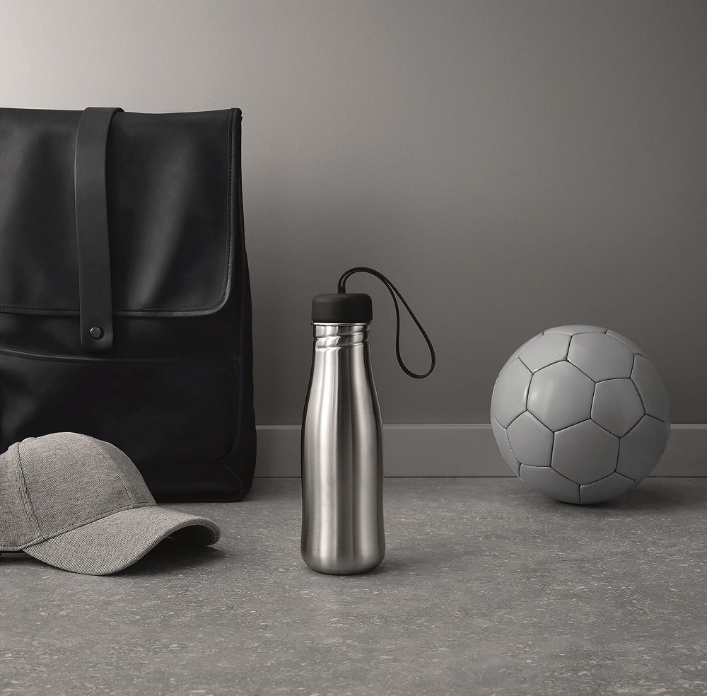 Edelstahl Trinkflasche mit schwarzem Deckel, Active Drinking bottle, neben Rucksack, Kappe und Fußball.