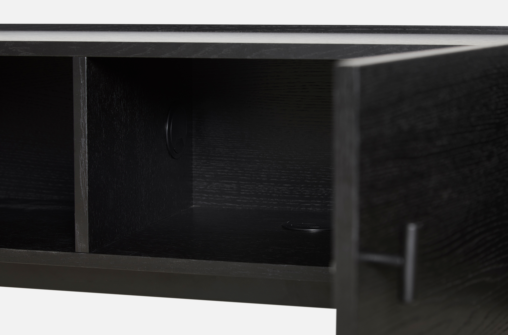 Detailaufnahme des Woud Array Low Sideboards (150cm) in Schwarz, mit offener Tür und Kabeldurchlass für TV-Möbel.