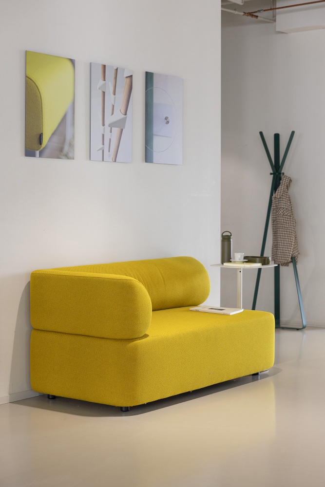 Gelbes Cascando Mezza Sitzelement Sofa mit abgerundeter Armlehne und minimalistischem Design für moderne Wohnräume.