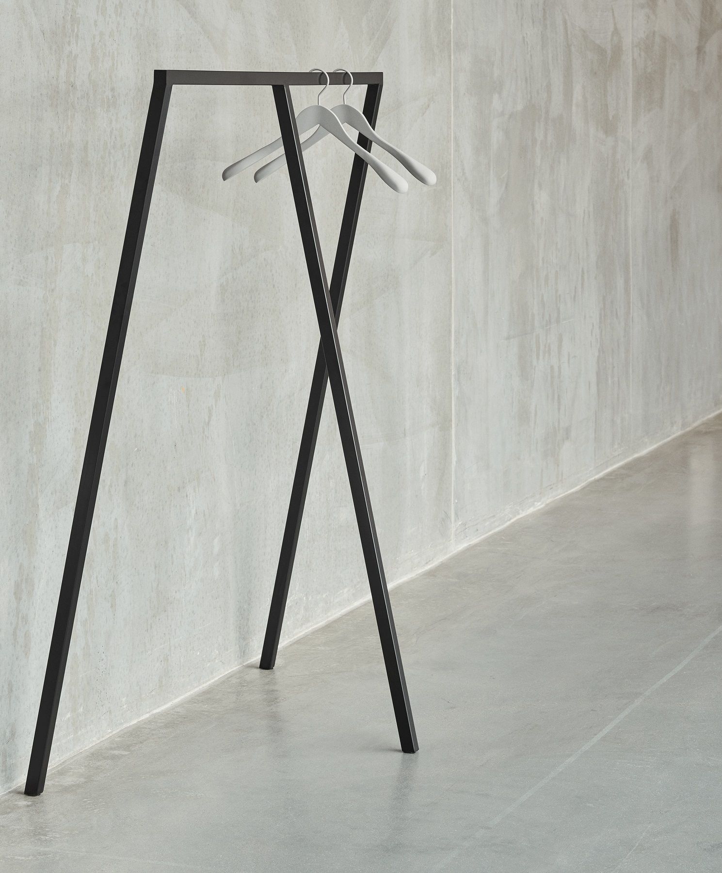 Hay Loop Stand Wardrobe Garderobe in Schwarz mit zwei Kleiderbügeln vor einer Betonwand.