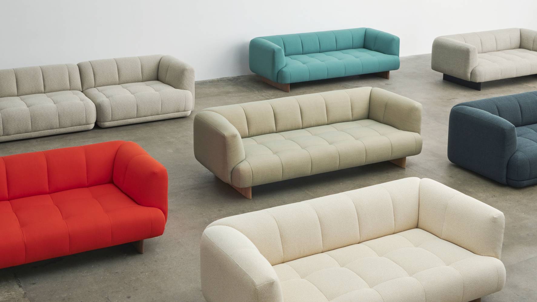 Mehrere Quilton Sofas von Hay in verschiedenen Farben und Stoffen auf einer Ausstellungsfläche.