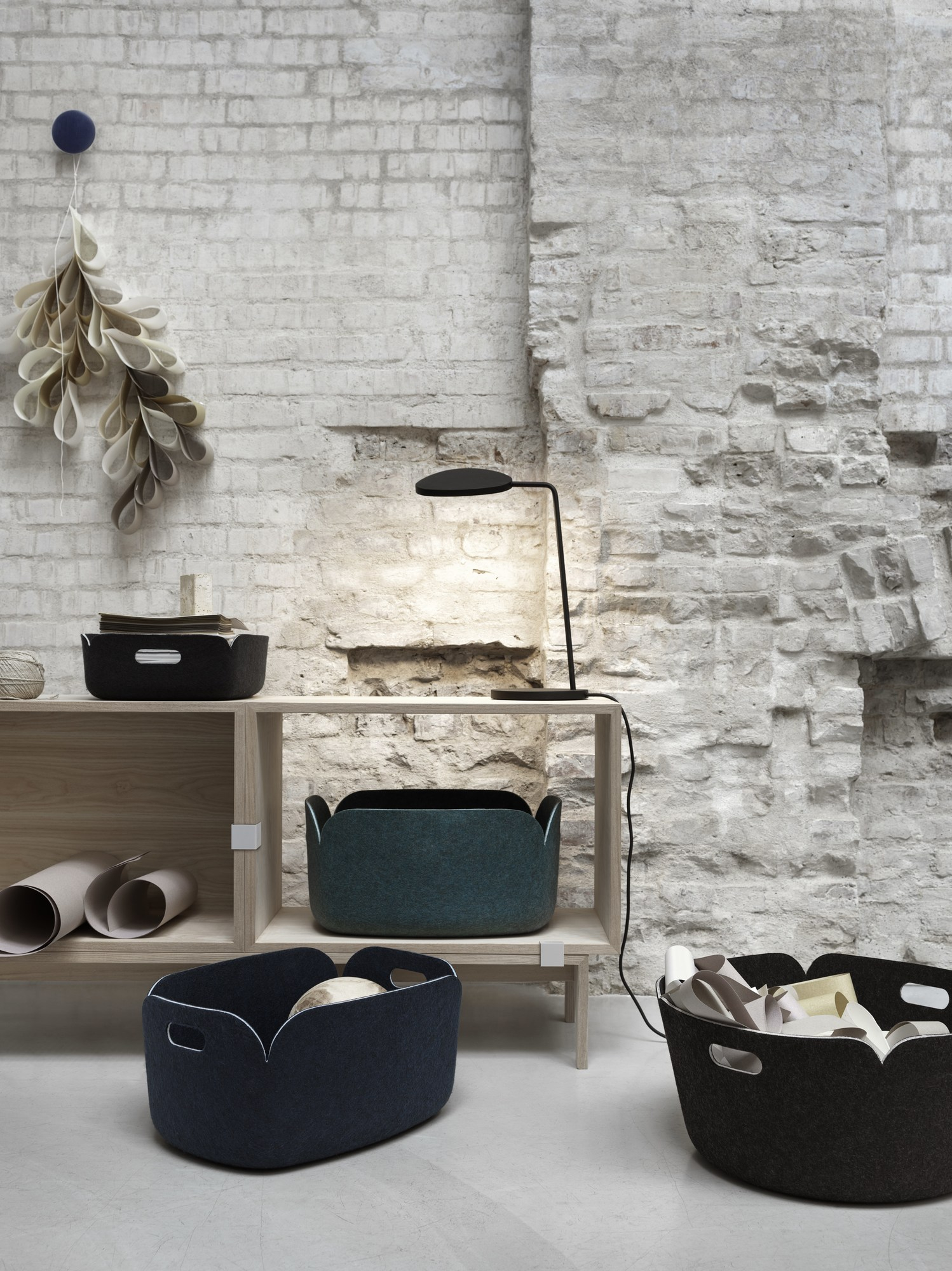 Verschiedene Muuto Restore Storage Körbe in Sand und anderen Farben auf einem Regal.