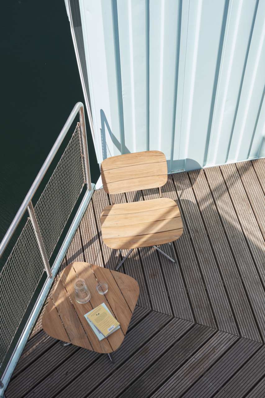 Lilium Lounge Chair von Skagerak: Holzstuhl für den Außenbereich auf einer Terrasse.