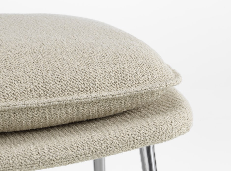 Detailaufnahme des Vitra Slow Chair Ottoman mit beigem Stoffbezug und Chromfüßen.