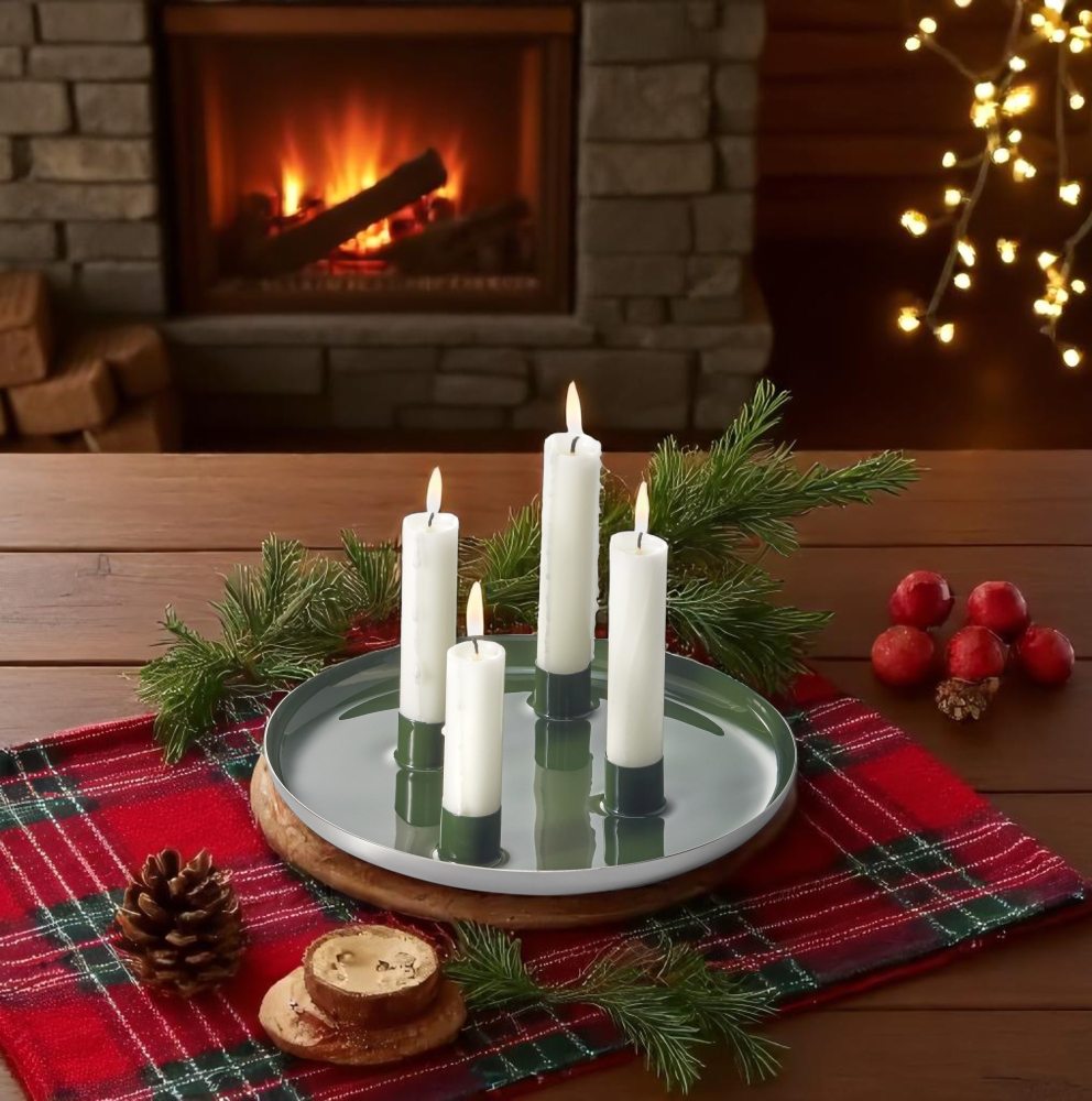 Biel Adventsteller von Philippi aus Stahl mit vier brennenden Kerzen und weihnachtlicher Dekoration.