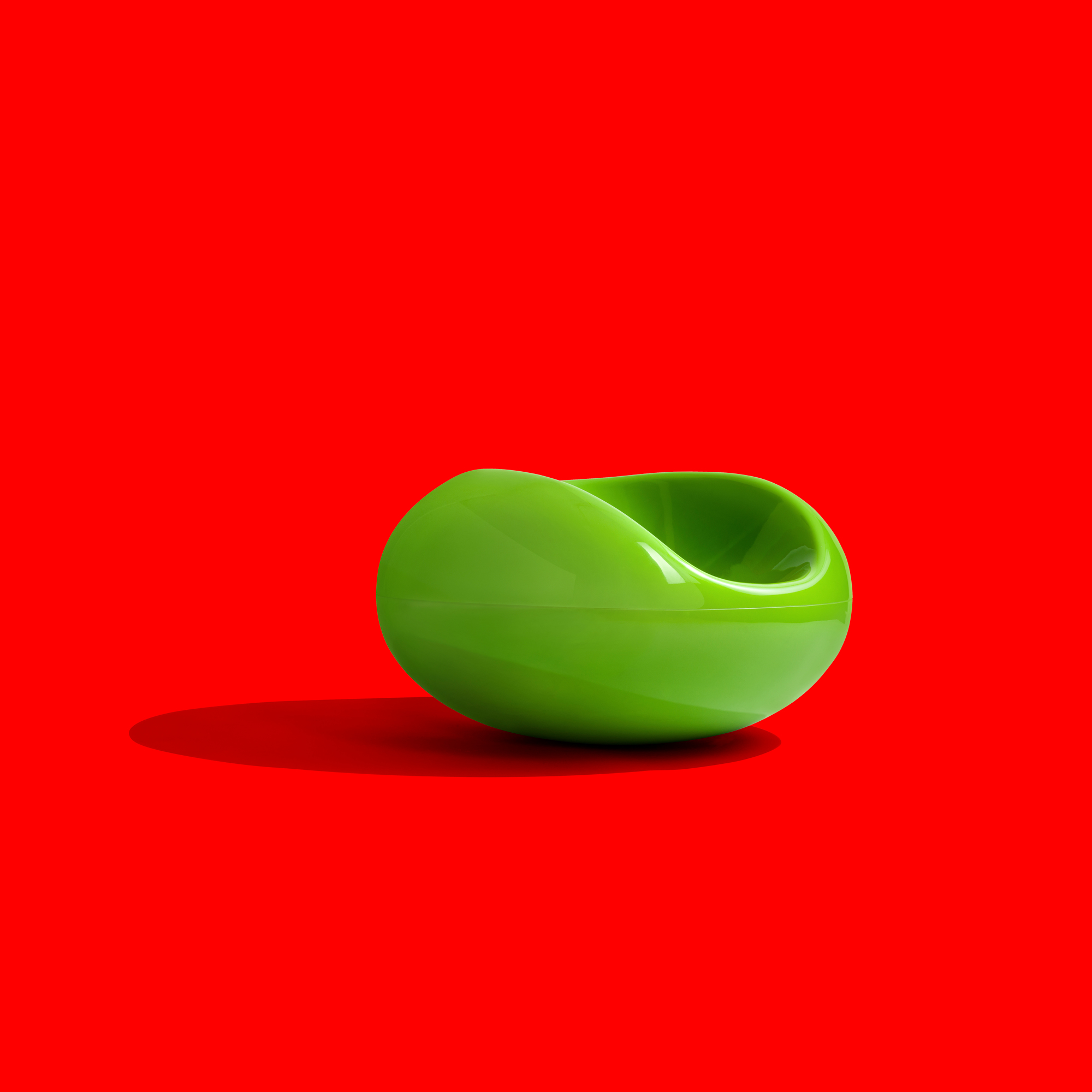 Grüner Pastil Stuhl von Eero Aarnio auf rotem Hintergrund. Designklassiker Sitzmöbel.