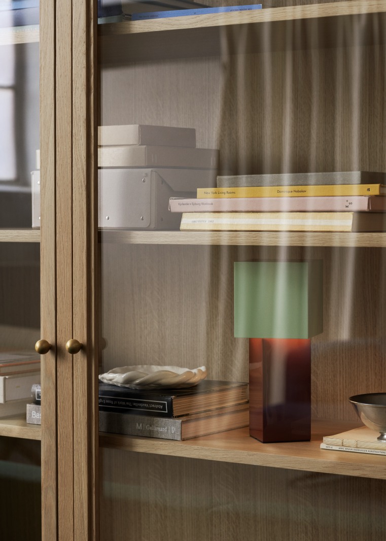 Pivot ATD7 Tischleuchte von AndTradition im Regal, modernes Design mit grünem Schirm.