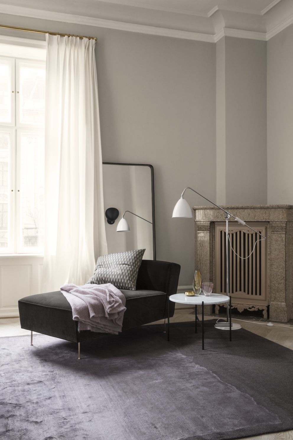 Adnet Spiegel von Gubi, rechteckig mit braunem Lederrahmen, in stilvollem Wohnzimmer mit Sofa und Teppich.