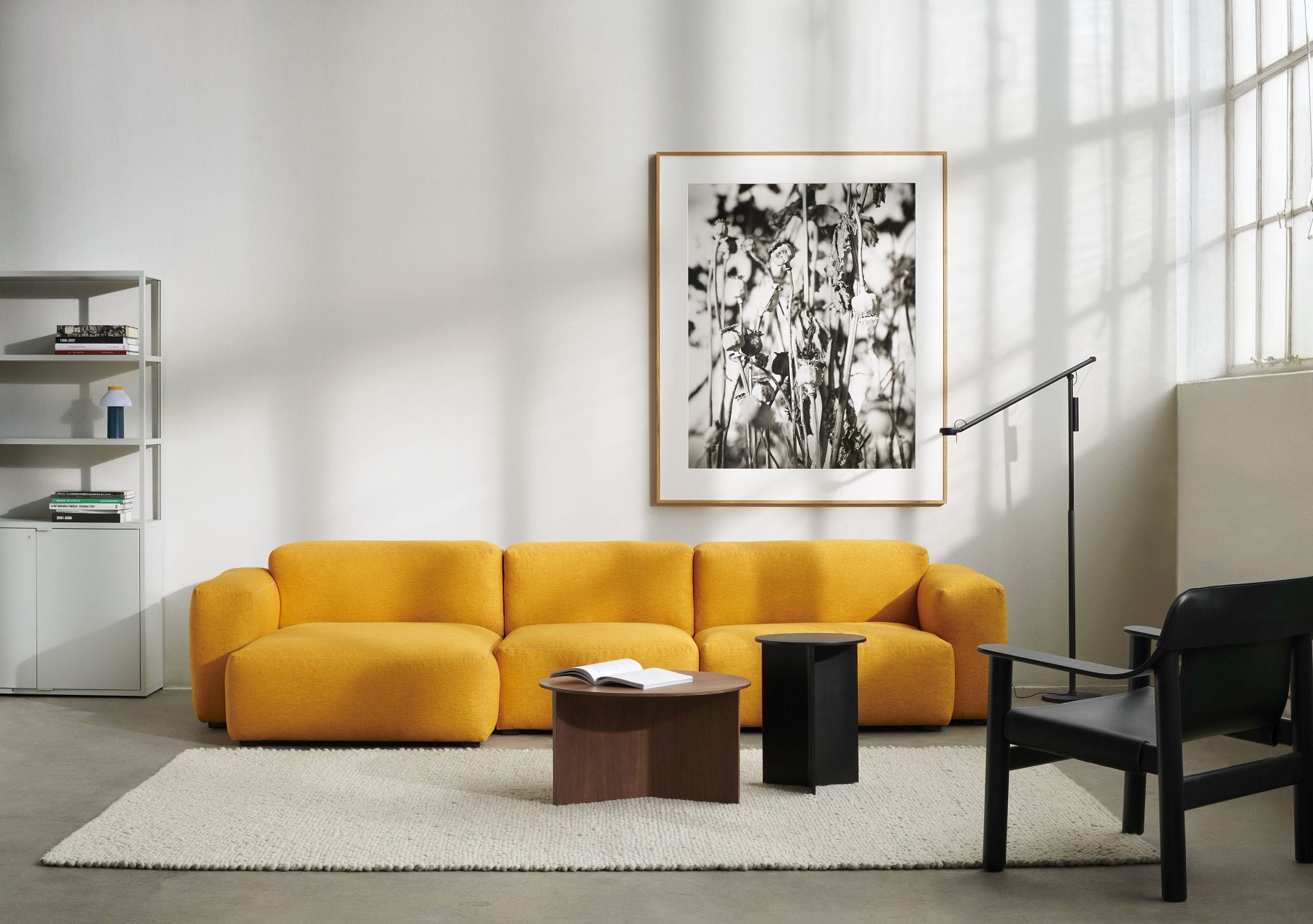 Wohnzimmer-Szene mit gelbem Sofa, Hay Slit Table Wood Round XL Beistelltisch und moderner Dekoration.