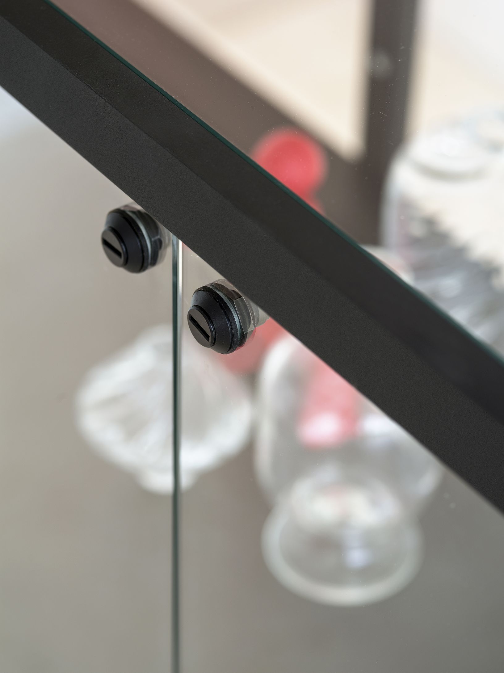 Detailaufnahme der Stolp High Vitrine Functionals: Schwarzer Rahmen und Glas mit Befestigungsdetails, Fokus auf Design und Verarbeitung.