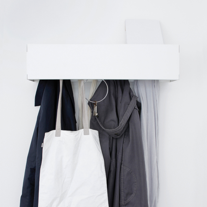 Weiße Wandgarderobe CR Linea1 mit Jacken, Schal und Tasche, modernes Design für Flur und Eingangsbereich.