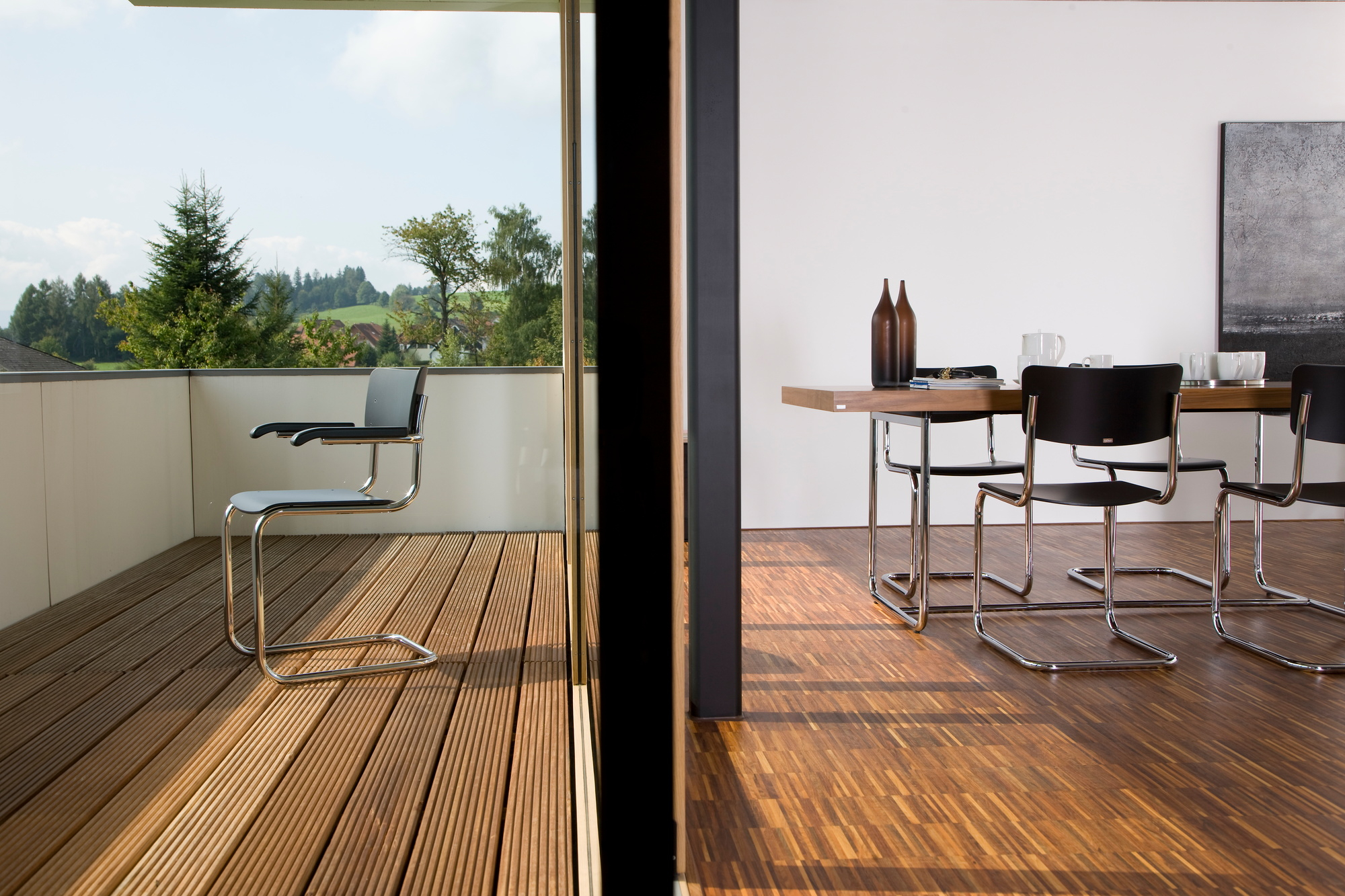 S 43 F Freischwinger von Thonet: Stahlrohrstuhl auf Terrasse und im Esszimmer mit Holzboden. Klassisches Design.