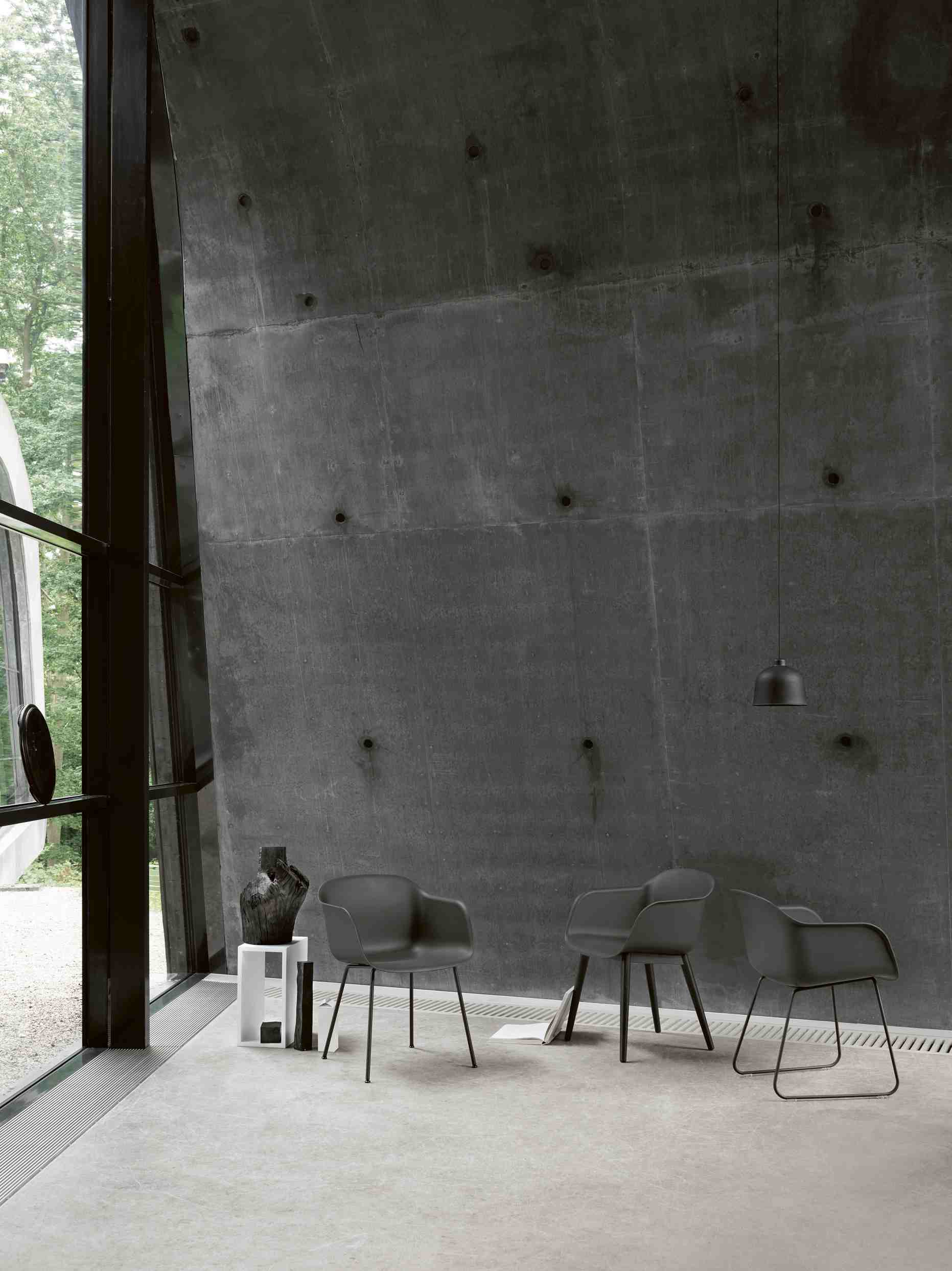 Innenaufnahme mit drei grauen Stühlen, Lampe und Beistelltisch. Muuto Regalsysteme und Möbel im modernen Design.