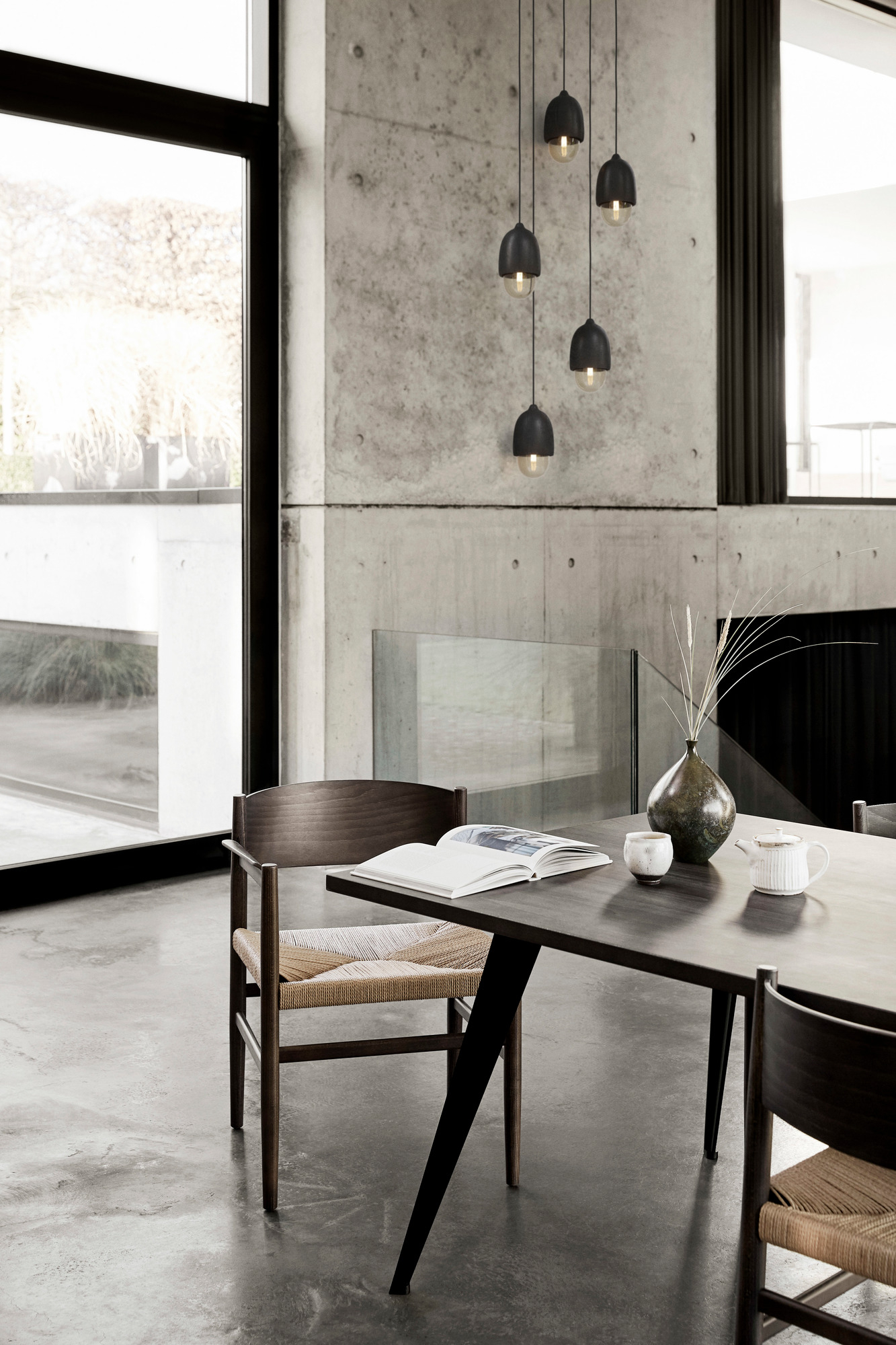 Moderner Esstisch von Mater mit Holzstühlen und minimalistischer Pendelleuchte in einem stilvollen Esszimmer.